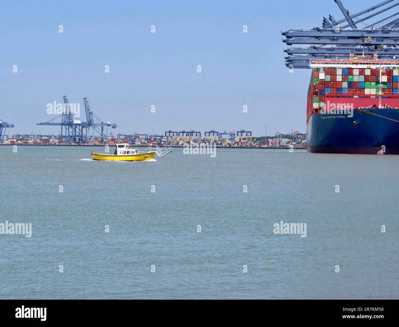 Felixstowe, Suffolk - 16 juin 2023 : petit traversier de port jaune, naguère alimenté par des grues et des navires à conteneurs dans le port de Harwich. Banque D'Images