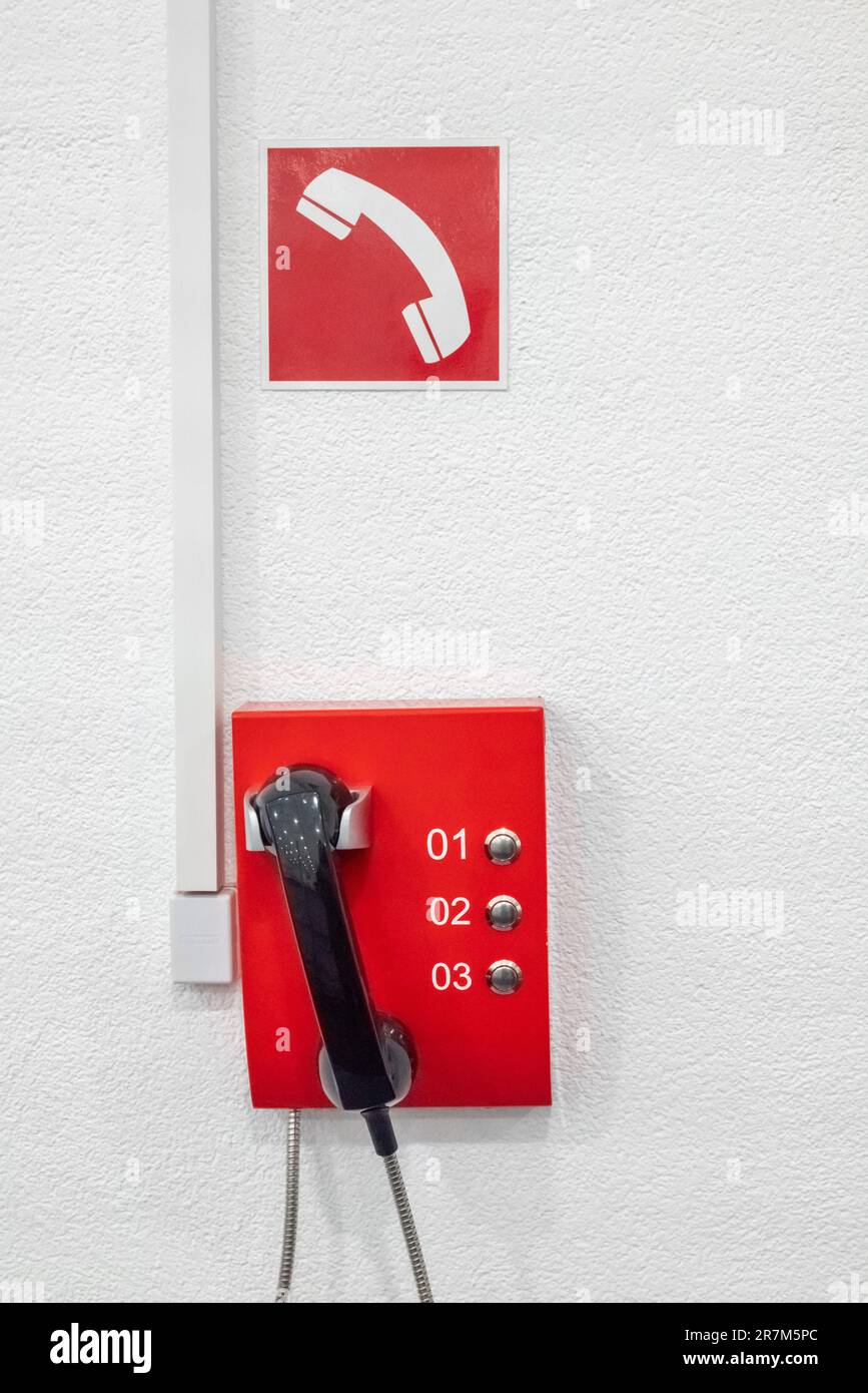 Le téléphone d'urgence rouge dans le bâtiment du bureau. Système téléphonique pour appeler l'alarme incendie. Banque D'Images