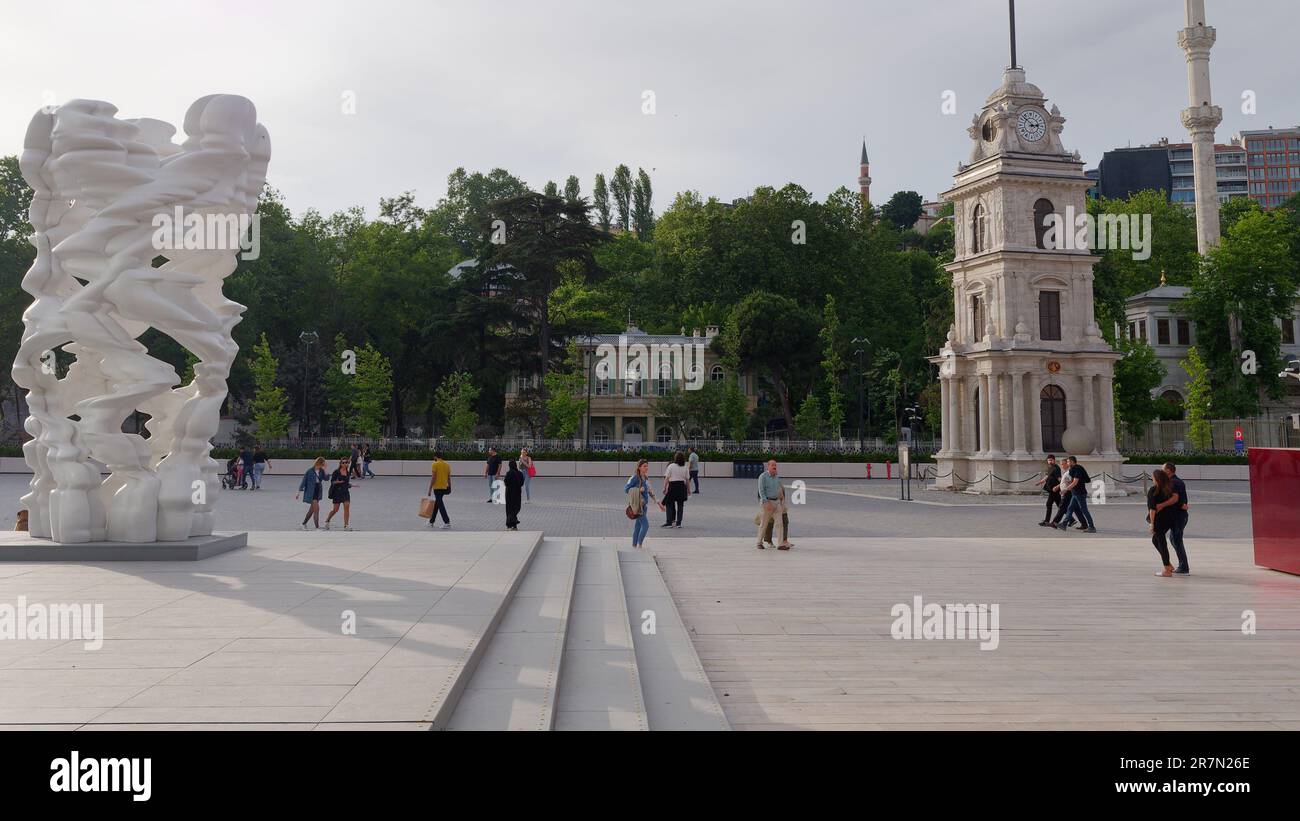 Clocher et œuvres d'art à Tophana aka Nusretiye, Istanbul, Turquie. Les gens passent devant profiter de la chaude soirée. Banque D'Images
