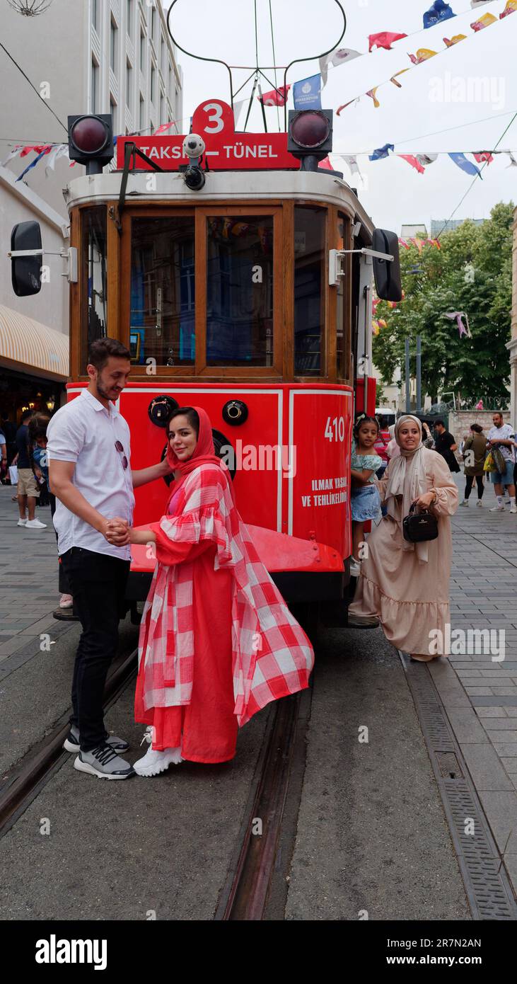 Des gens posant pour une photo près du Red Heritage Tram dans la rue Isticlal à Istanbul, Turquie Banque D'Images