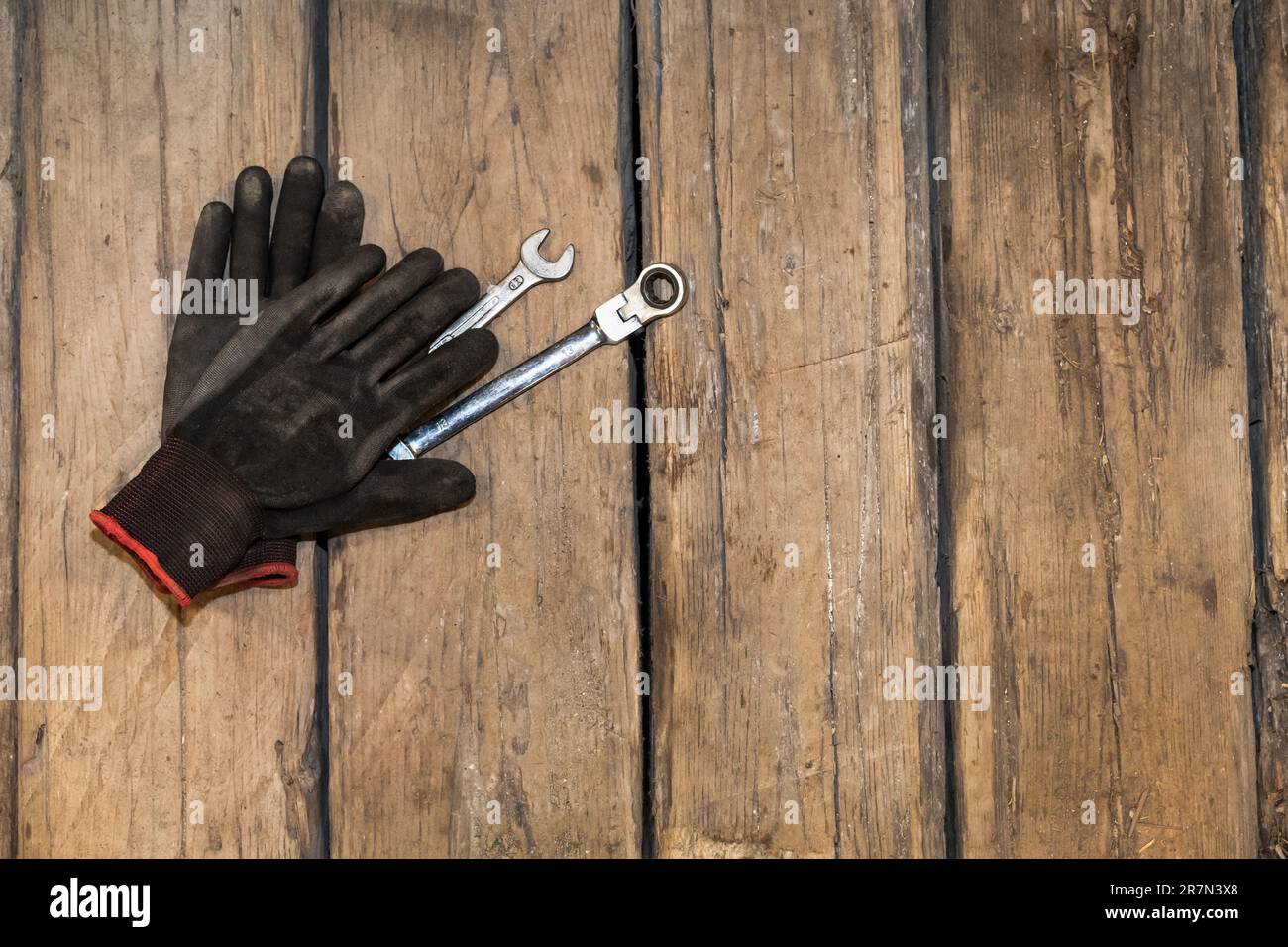 Gants de protection, clé polygonale et clé sur le plancher en bois. Banque D'Images