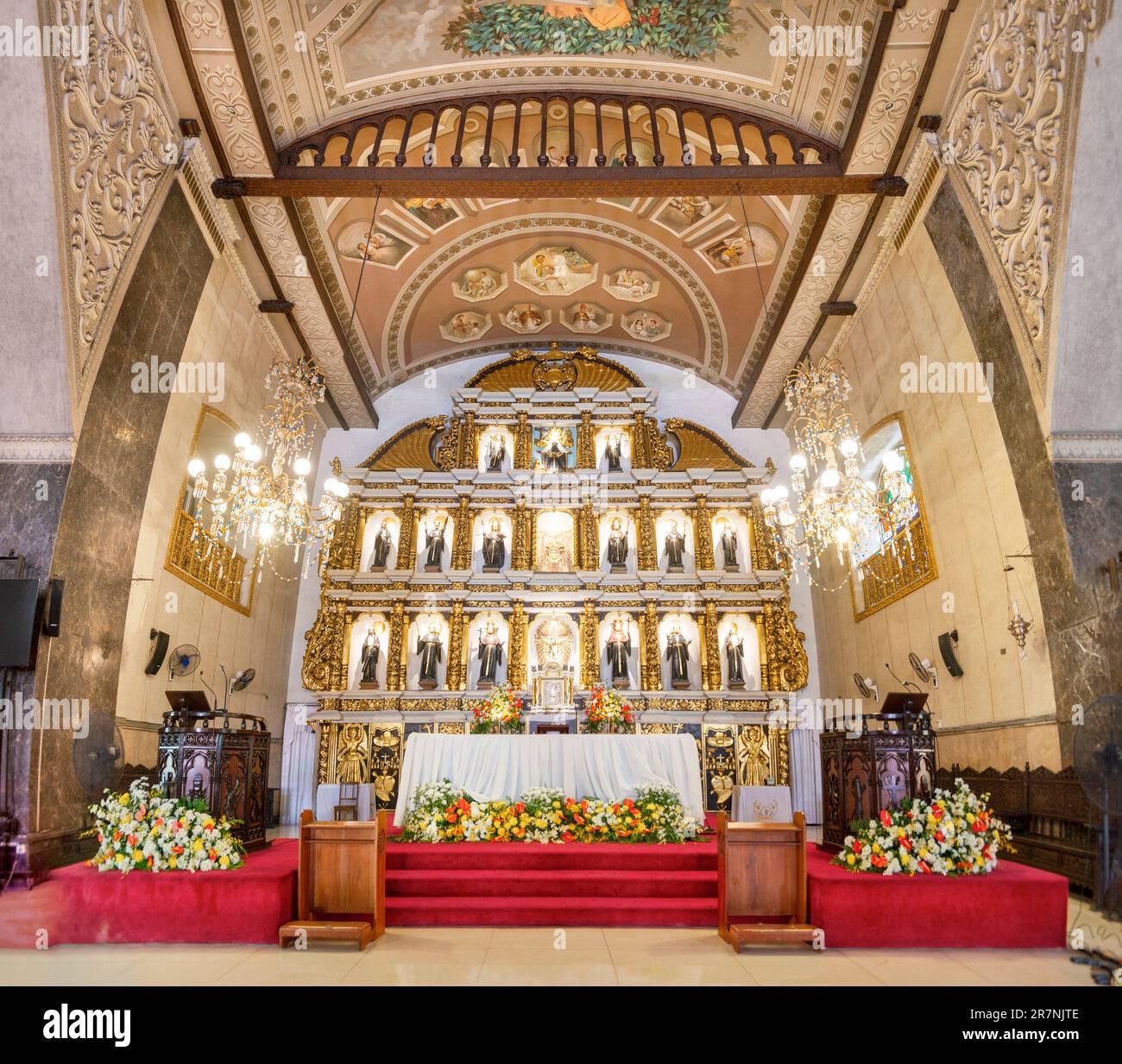 Cebu ville,Cebu,Philippines-17 janvier 2023:l'autel d'or, entouré de fleurs fraîches et tapis rouge, est honoré avec des images emblématiques de saints, anges, Banque D'Images