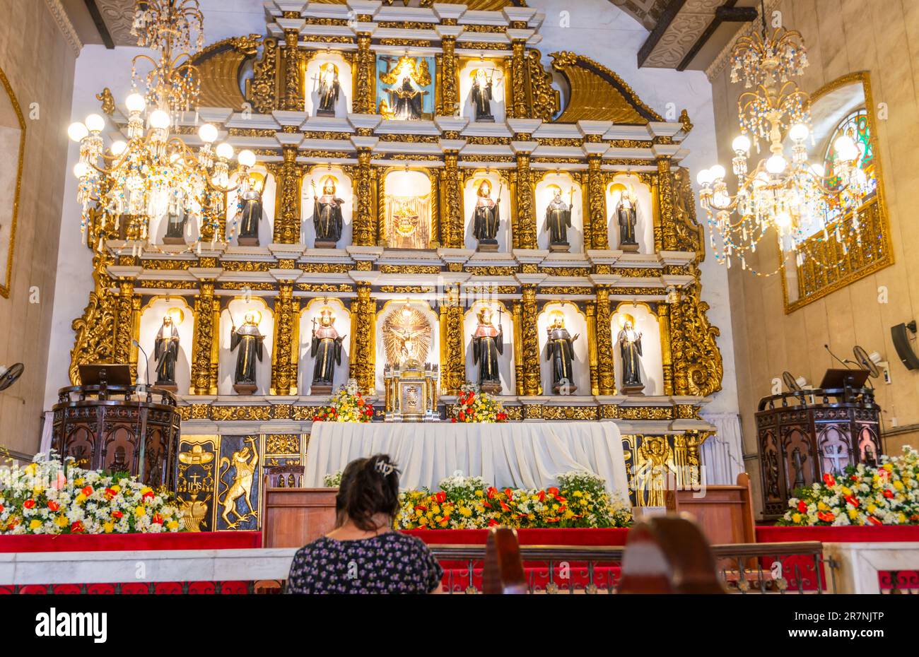 Cebu, Cebu, Philippines-17 janvier 2023: Beaucoup de catholiques philippins dévorés, viennent à genoux, prient et rendent grâce à l'autel, avec ses saints, ses anges, et Banque D'Images