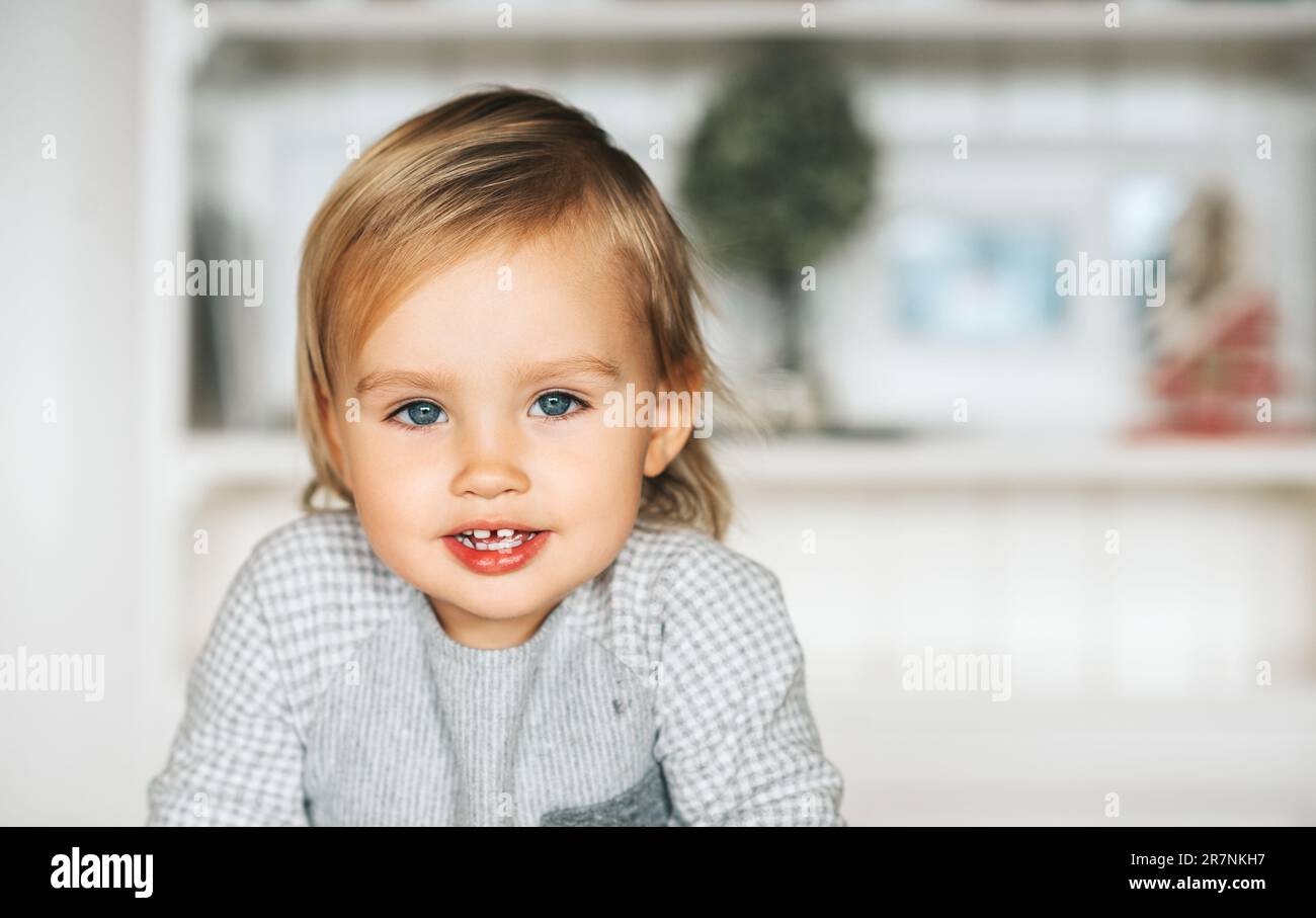Gros plan portrait de bébé adorable, en regardant directement l'appareil photo, les cheveux blonds, les yeux bleus Banque D'Images