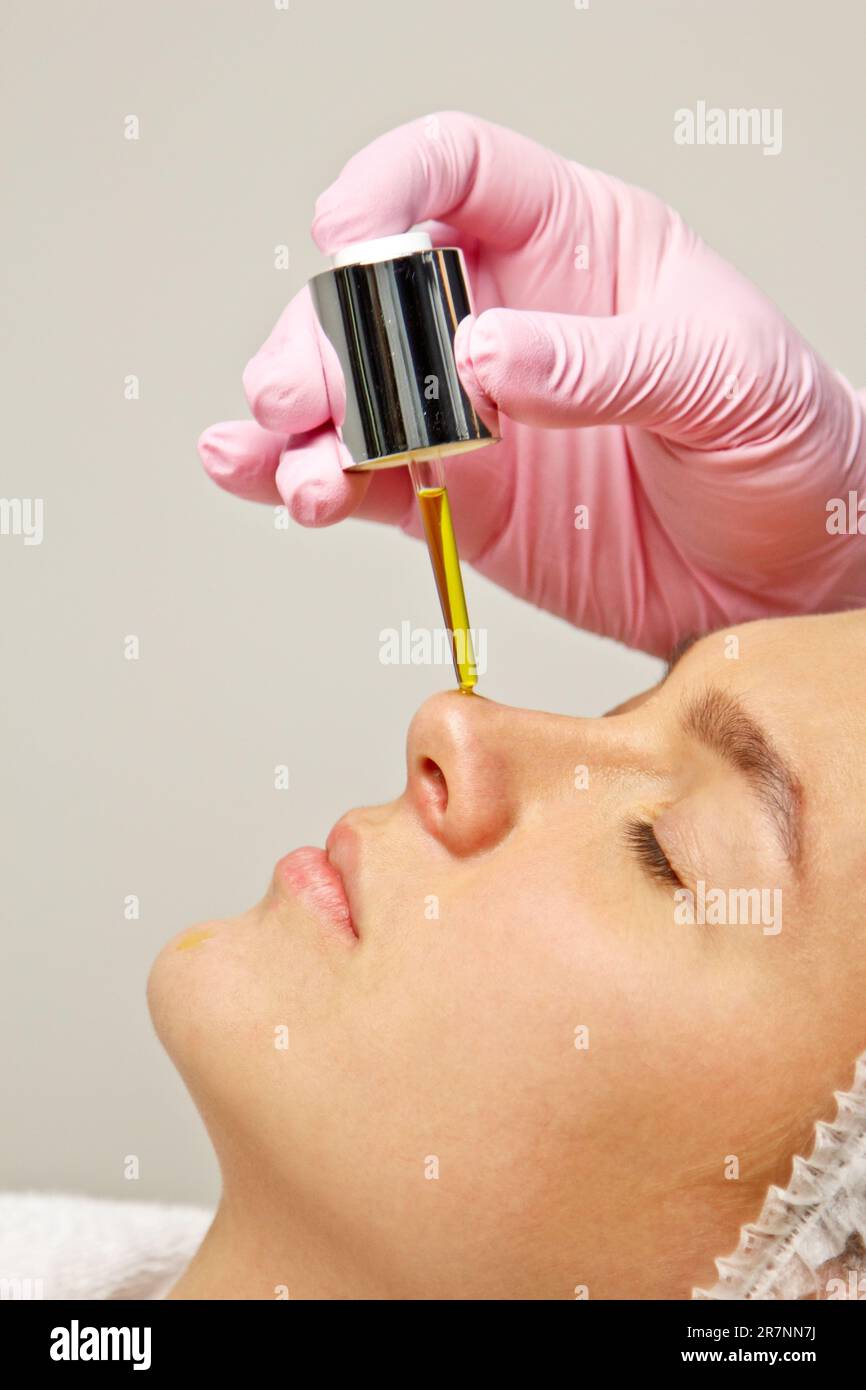 préparation des procédures dans le bureau du cosmétologue. appliquer de l'huile pour hydrater le visage avec une pipette spéciale Banque D'Images