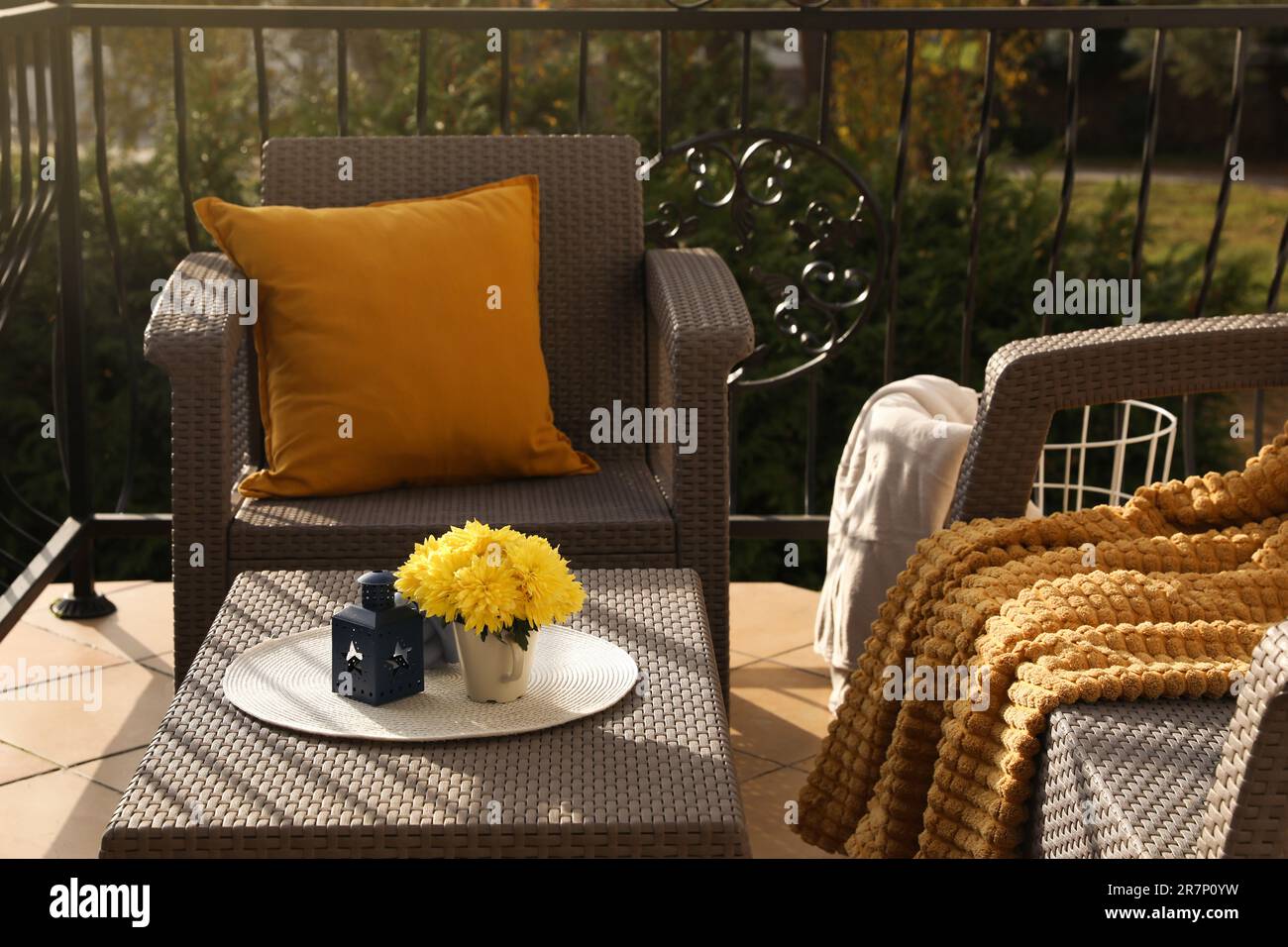 Coussin orange, couverture douce et fleurs de chrysanthème jaunes sur  meubles de jardin en rotin à l'extérieur Photo Stock - Alamy