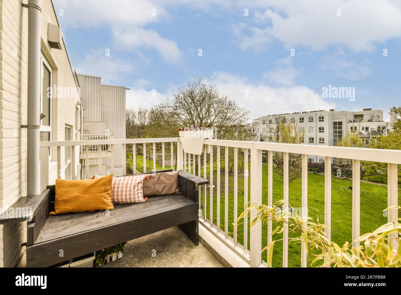 un balcon avec un banc sur la gauche et quelques bâtiments dans le sol arrière à droite, il ya un ciel bleu vif Banque D'Images