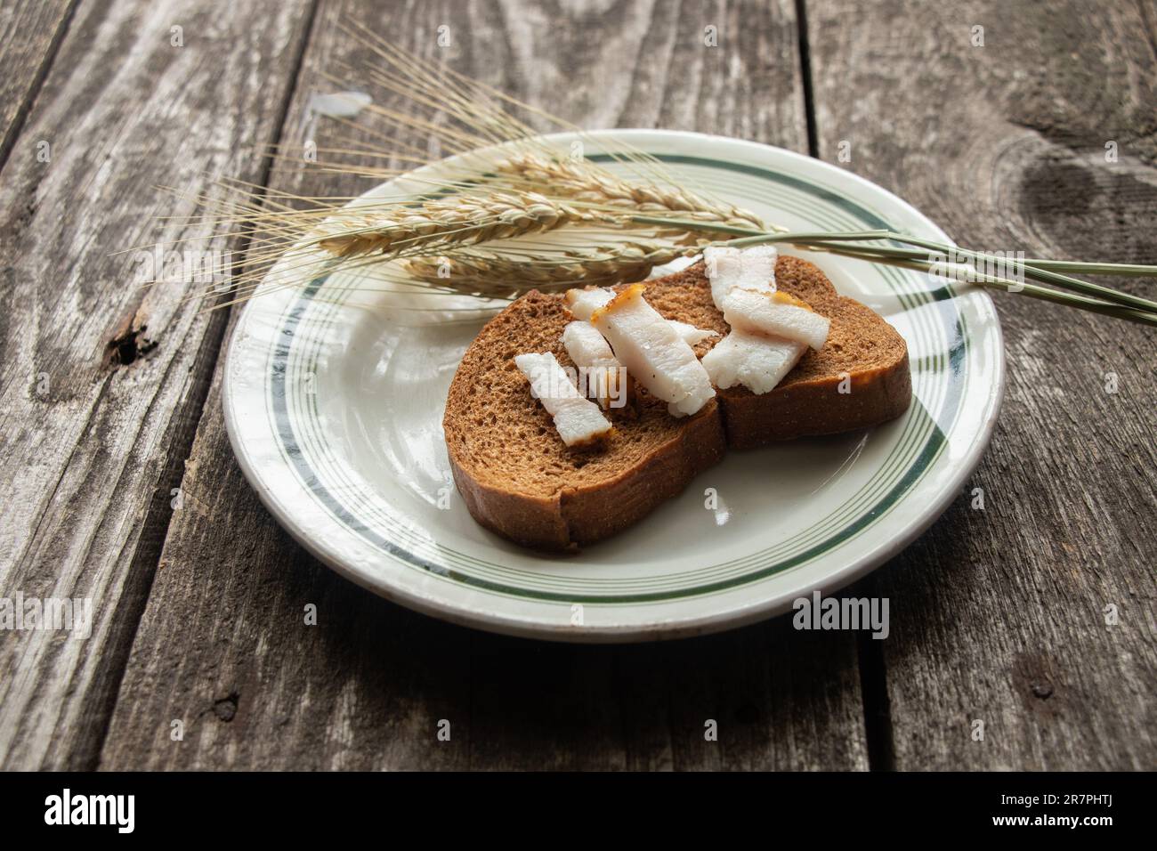 tranche de pain noire avec bacon sur une assiette sur une table en bois pour le déjeuner Banque D'Images tranche de pain noire avec bacon sur une assiette sur une table en bois pour le déjeuner Banque D'Images