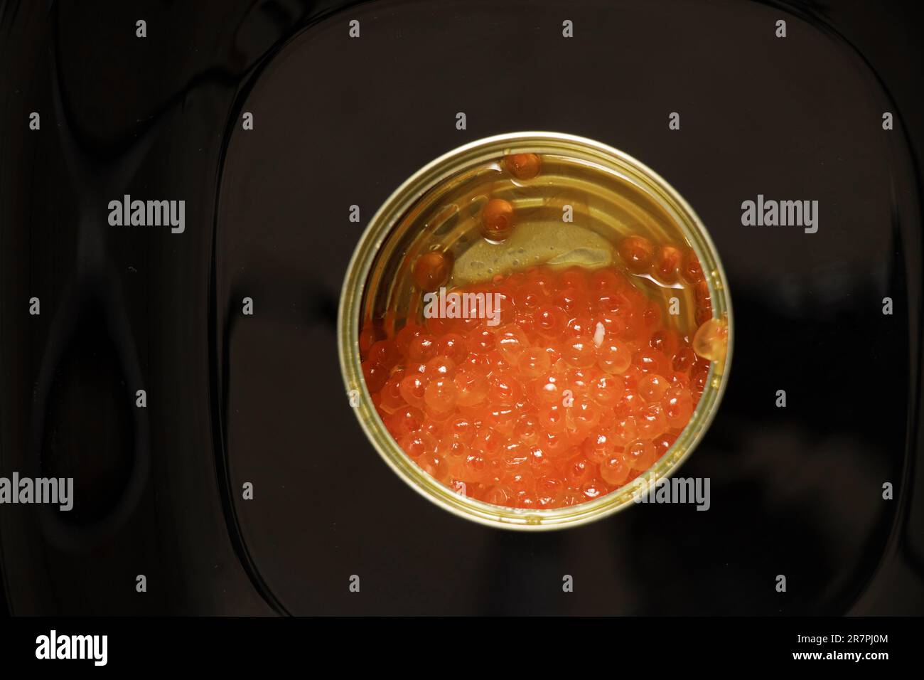 boîte de fer avec caviar de saumon rouge sur fond noir Banque D'Images