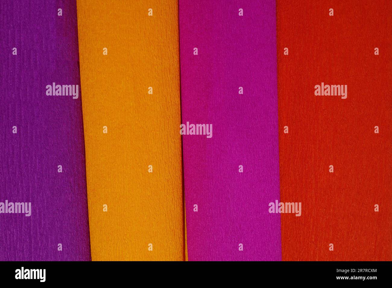 Rouleaux de papier crêpe couchés l'un à côté de l'autre dans les couleurs pourpre, rouge, orange, lilas Banque D'Images