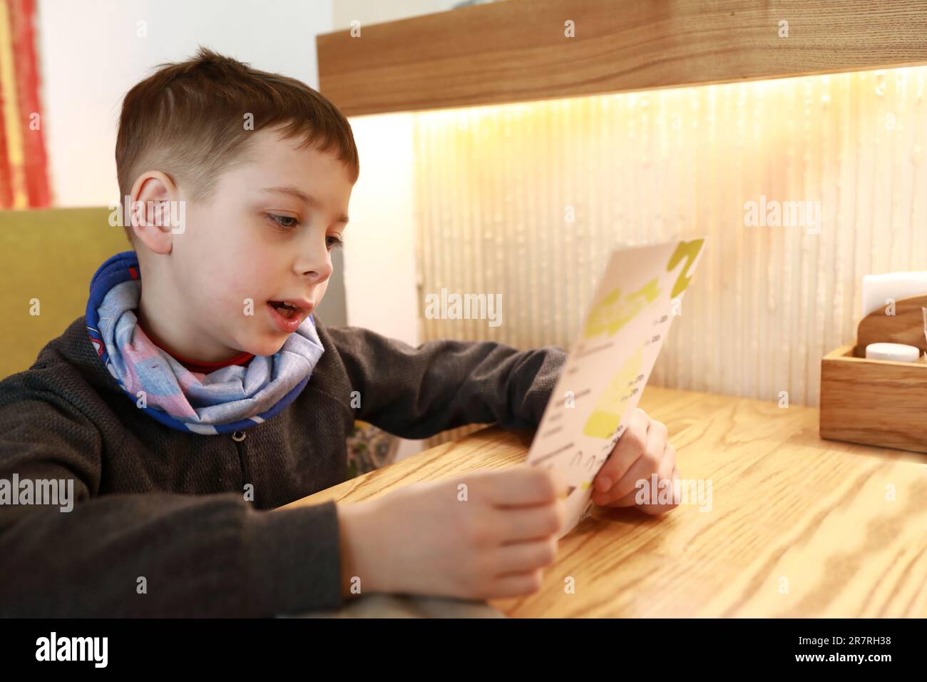 Enfant choix de plats par menu au restaurant Banque D'Images