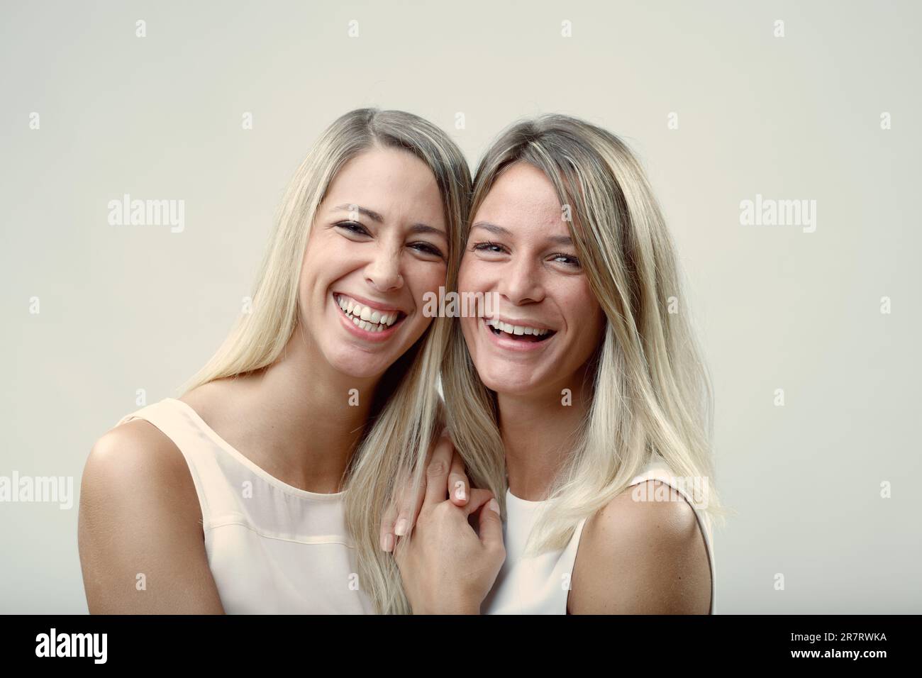Deux blonds, des amis comme des sœurs, câliner et échanger des baisers dans un portrait amical d'affection et de compagnie Banque D'Images