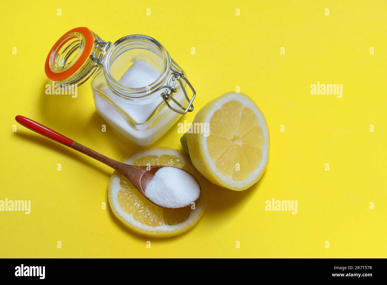 Acide citrique dans une cuillère en bois et un récipient en verre, citron Banque D'Images