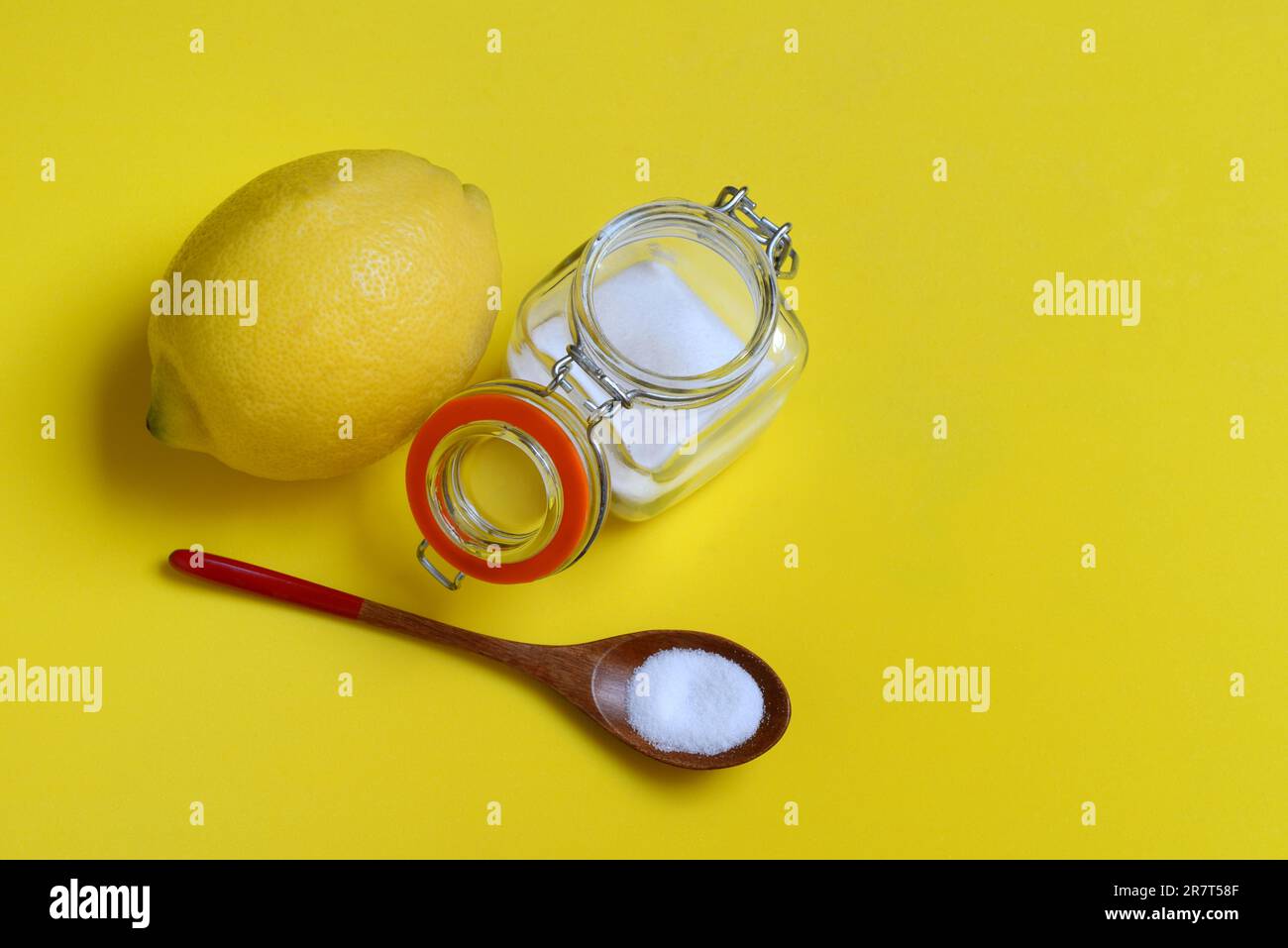 Acide citrique dans une cuillère en bois et un récipient en verre, citron Banque D'Images