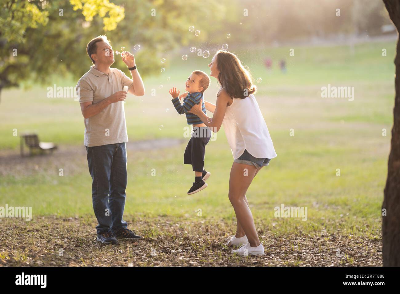 Bonne famille blanche passant du temps dans le parc - le père soufflant des  bulles de savon et sa femme et son fils souriant. Mid shot Photo Stock -  Alamy