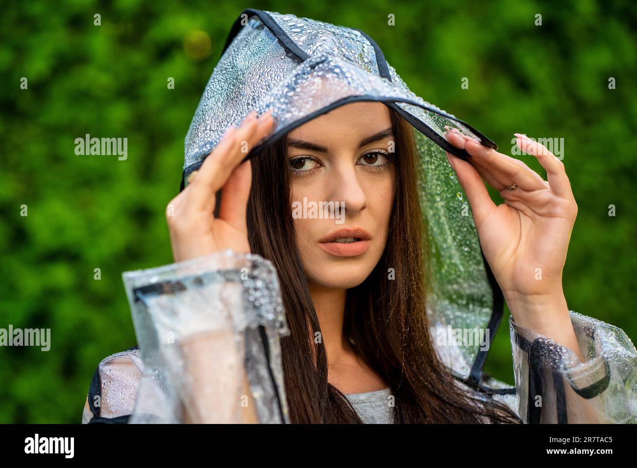 Jeune belle femme en imperméable à capuche le jour de la pluie Banque D'Images