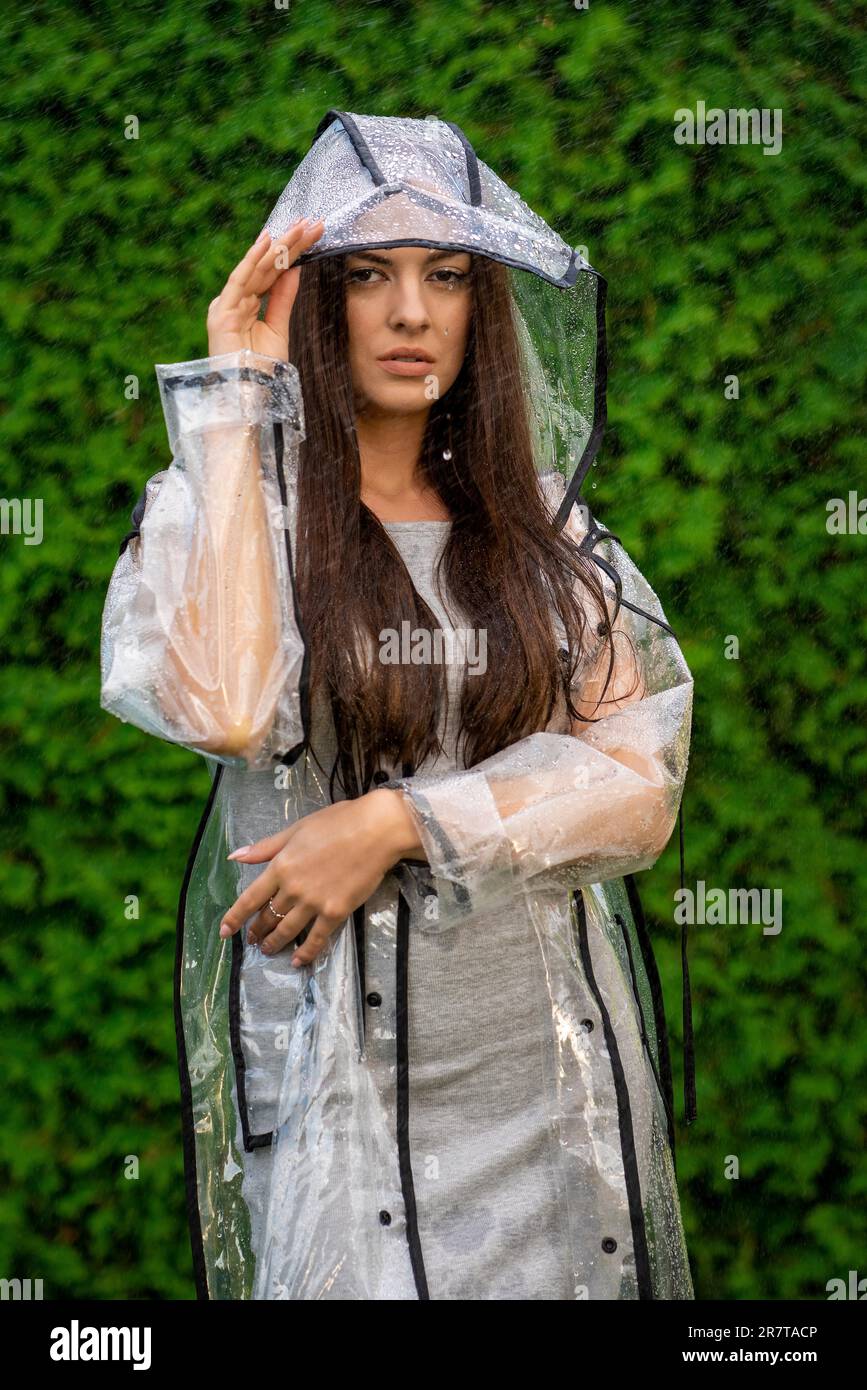 Jeune belle femme en imperméable à capuche le jour de la pluie Banque D'Images