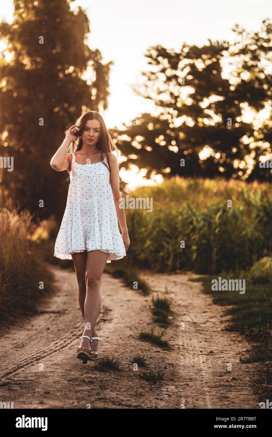 Jeune belle femme en robe blanche dans champ de maïs Banque D'Images