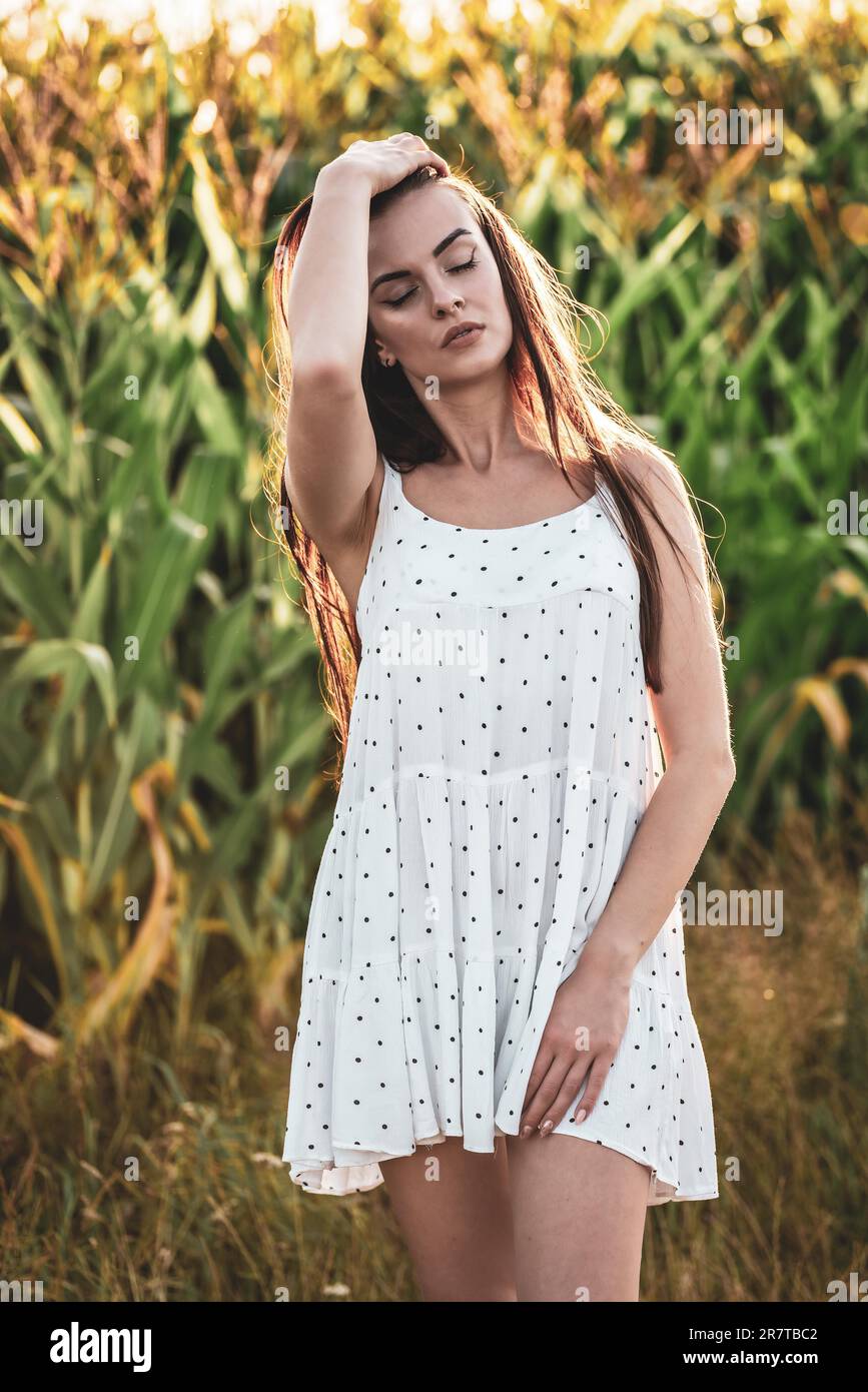 Jeune belle femme en robe blanche dans champ de maïs Banque D'Images