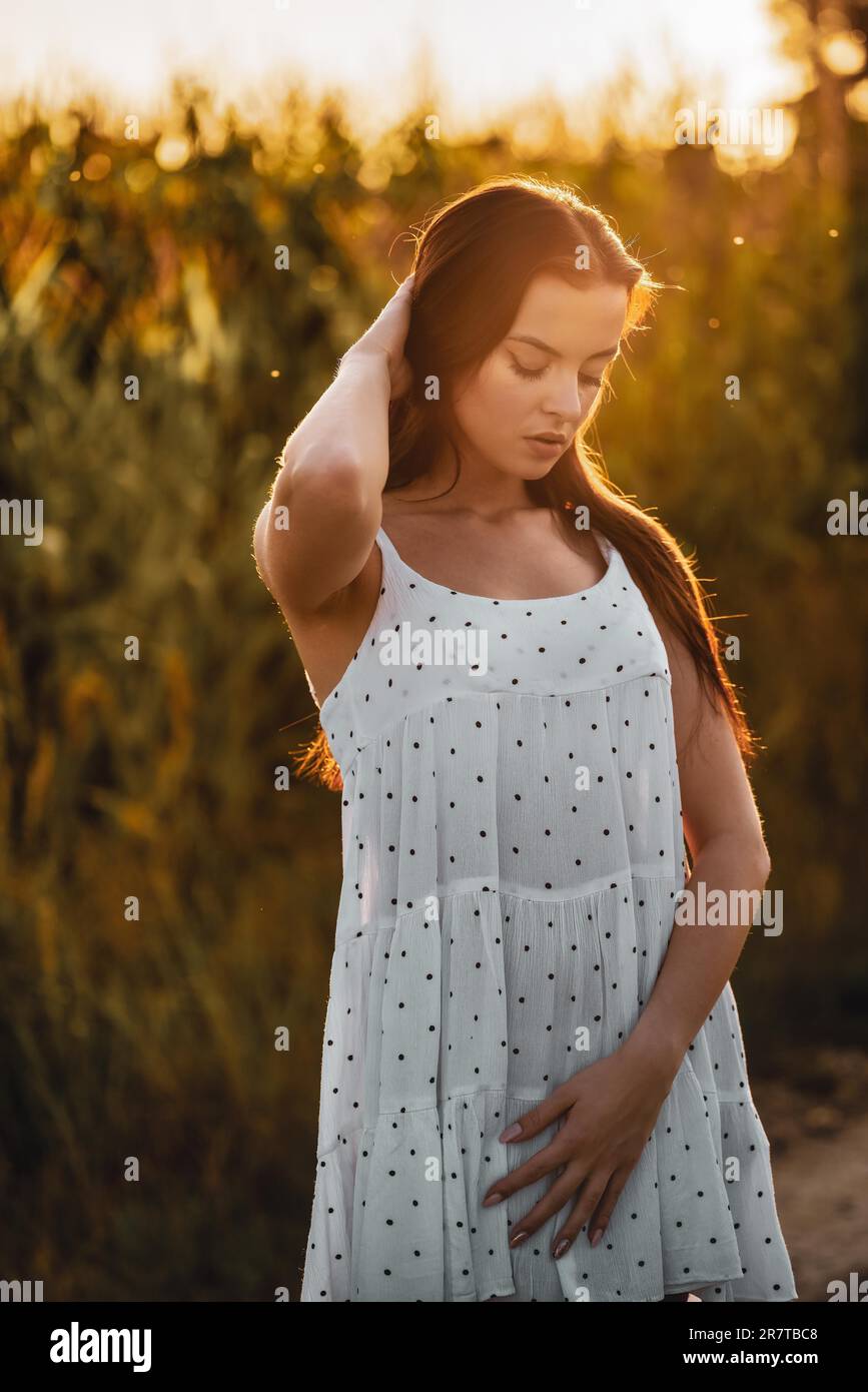 Jeune belle femme en robe blanche dans champ de maïs Banque D'Images