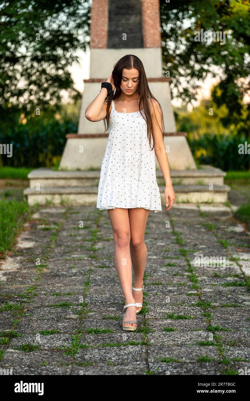 Jeune belle femme avec cheveux bruns en robe blanche Banque D'Images