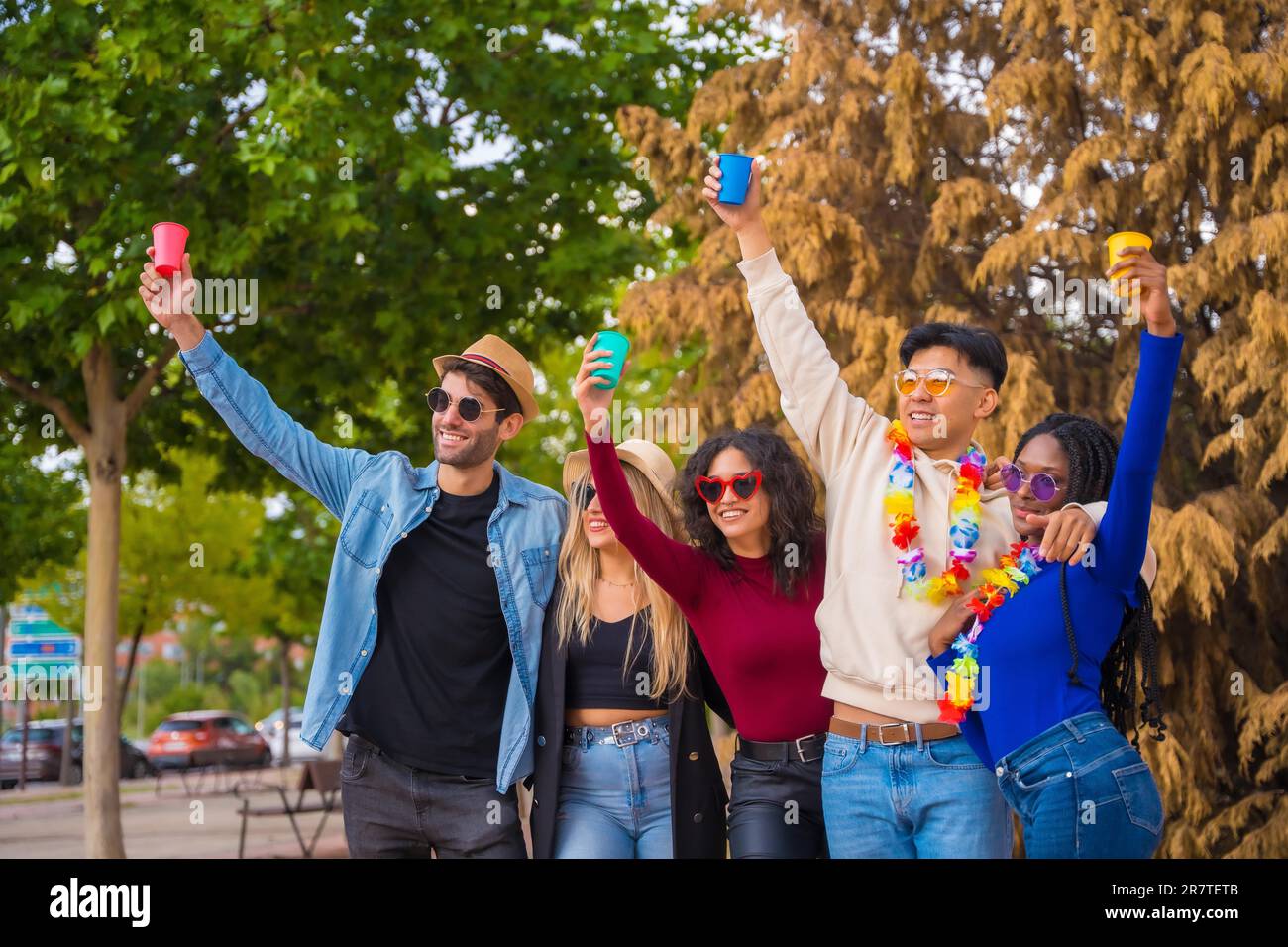 Portrait de groupe d'amis multiethniques ayant une fête dans un parc, de jeunes divers avec des verres de bière élevés lors d'une fête d'été, happy hour, déjeuner Banque D'Images