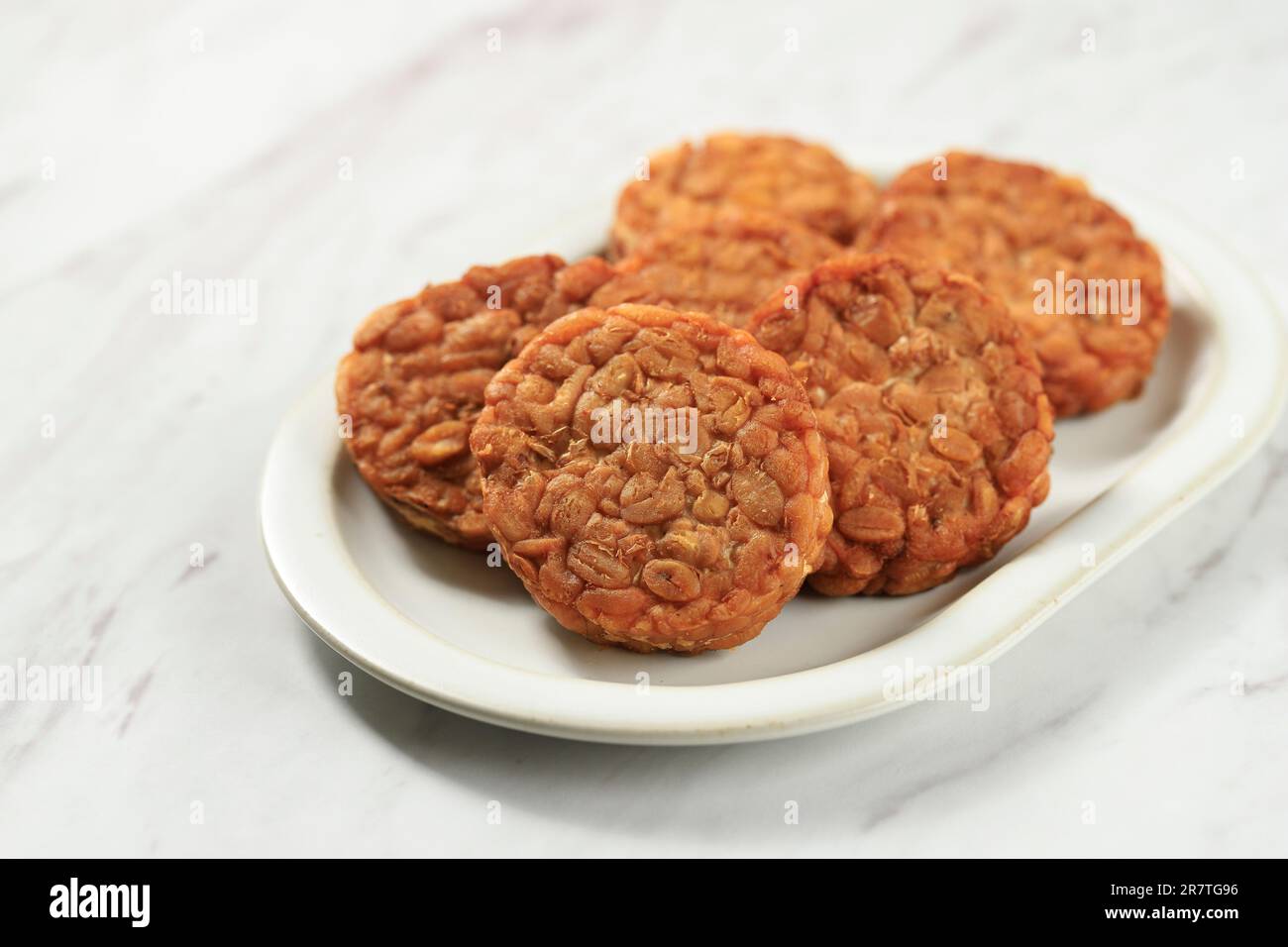 Tempeh rond ou Tempe Goreng. Tempe est un aliment indonésien traditionnel à base de soja fermenté. Banque D'Images