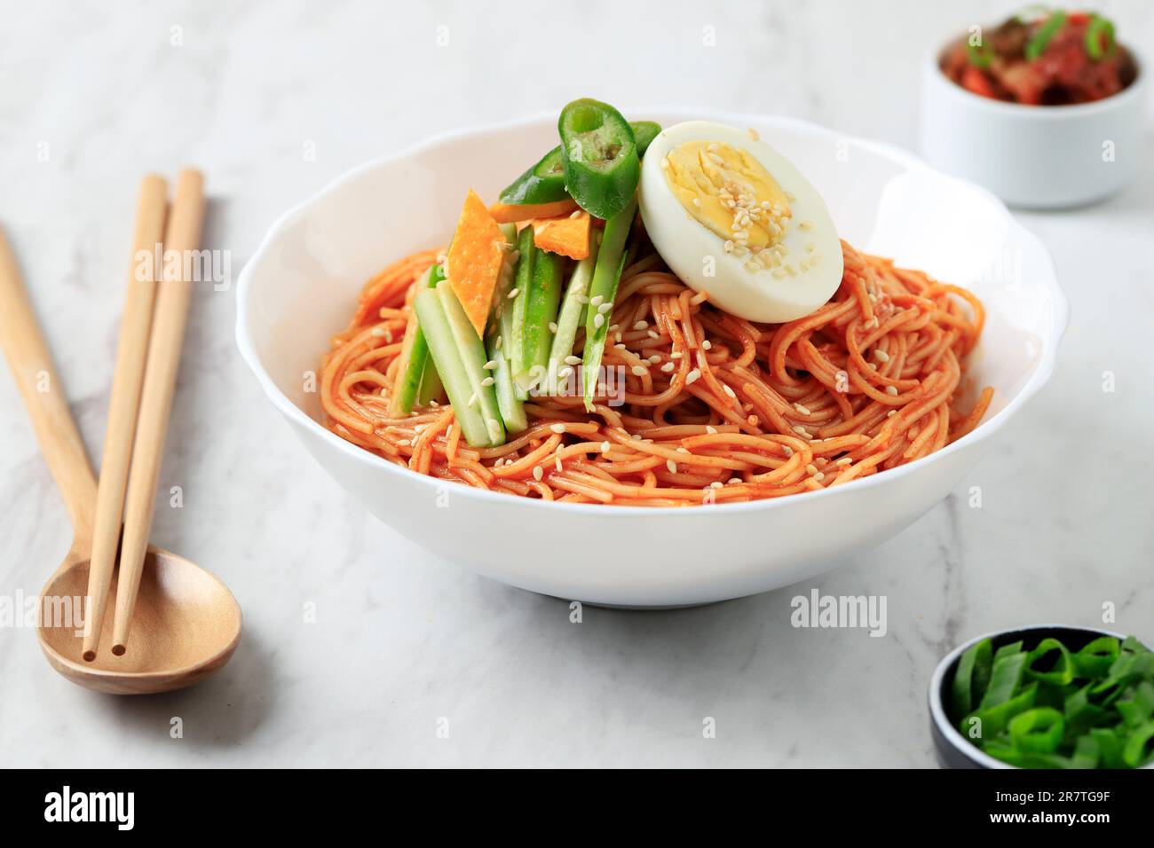 Bibim Guksu Naengmyeon, mélo-coq coréen avec concombre en tranches et garniture aux œufs durs. Sur une table en marbre blanc Banque D'Images