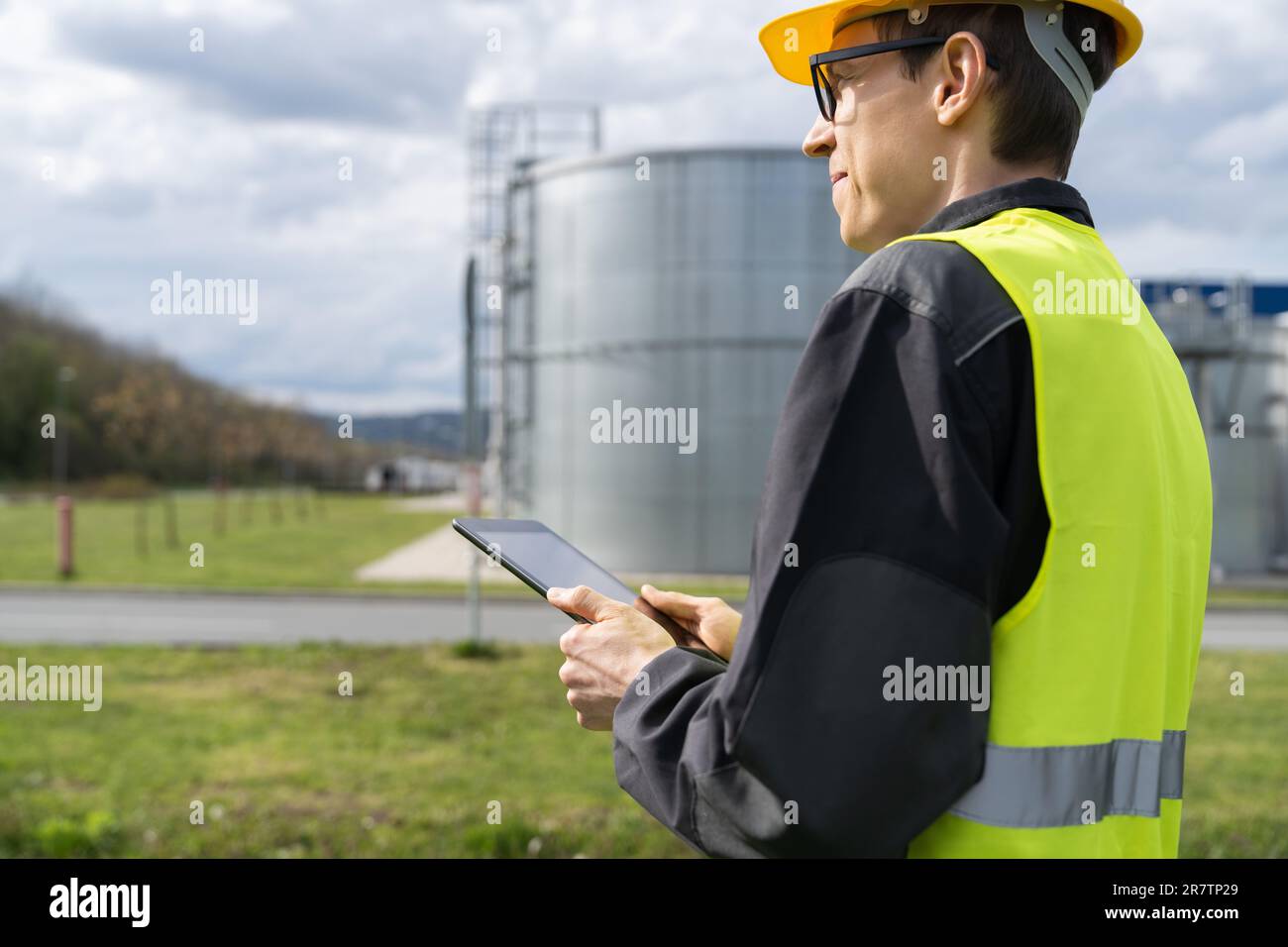 Concevoir avec une tablette numérique sur un fond de réservoirs de gaz. Banque D'Images