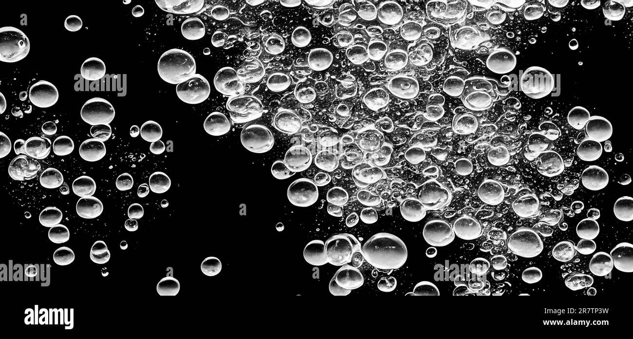 Bulles d'eau de soude éclaboussant sous l'eau sur fond noir. Cola liquide texture qui fend et flotte jusqu'à la surface comme une explosion en uedn Banque D'Images