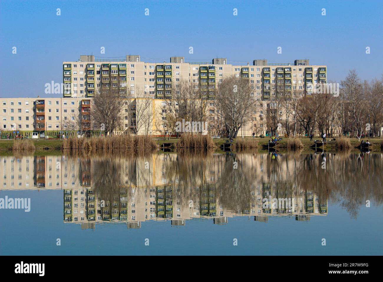 Maisons en panneaux se tenant sur la rive d'un lac, reflétées dans l'eau. Immobilier en Hongrie. Banque D'Images