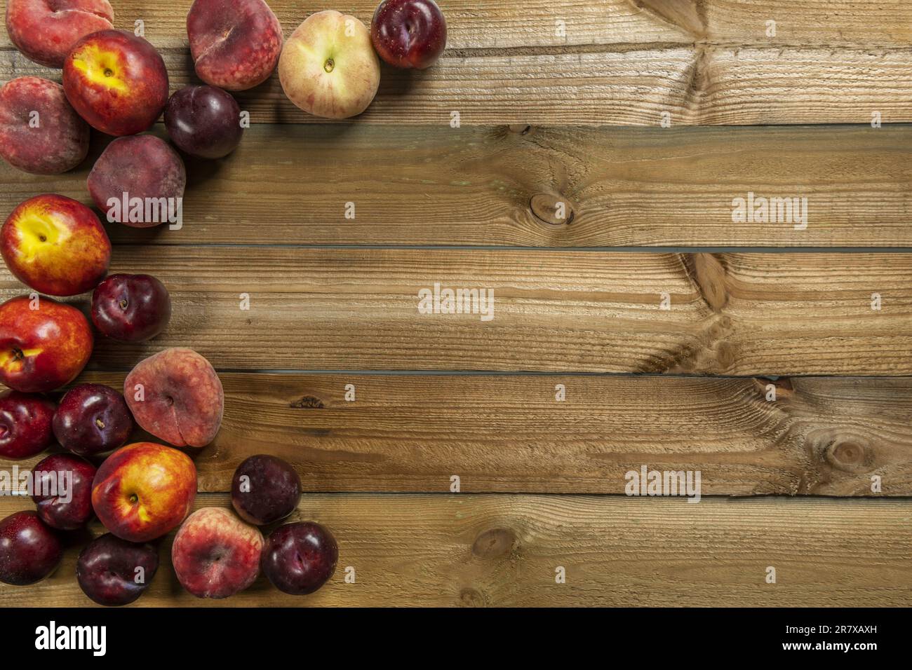 Encore la vie de fruits mûrs avec prunes, nectarines, paraguayans sur des planches en bois Banque D'Images