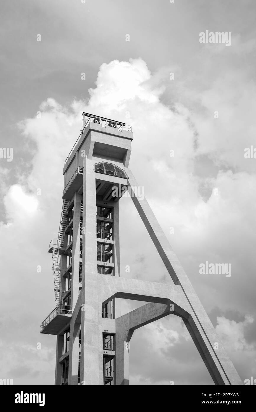 La tour de l'ancien puits de mine contre le ciel bleu. Actuellement une tour d'observation. Un monument de la technologie. Photo en noir et blanc. Arbre préd Banque D'Images