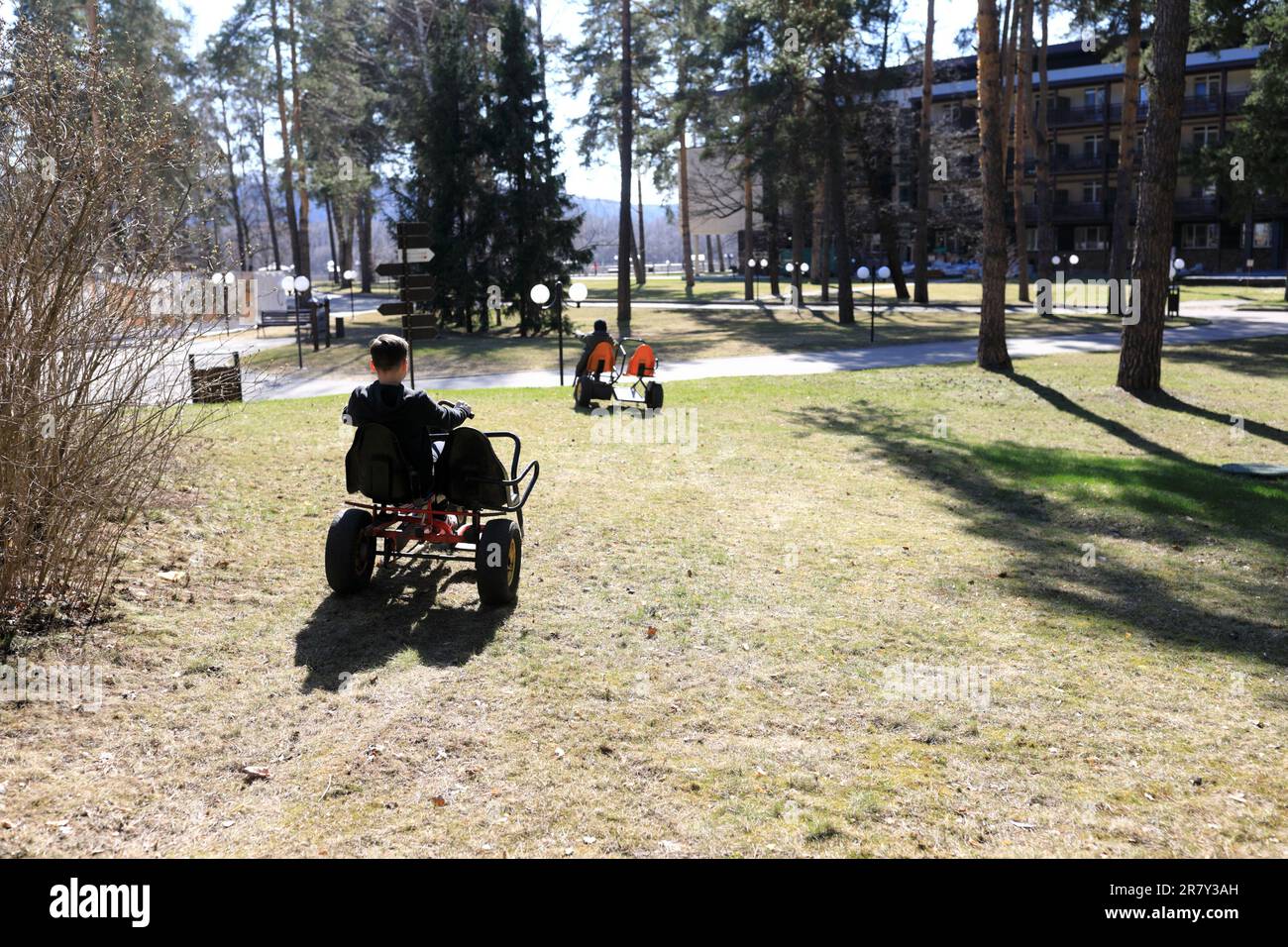 Enfants en tricycles dans le parc au printemps Banque D'Images
