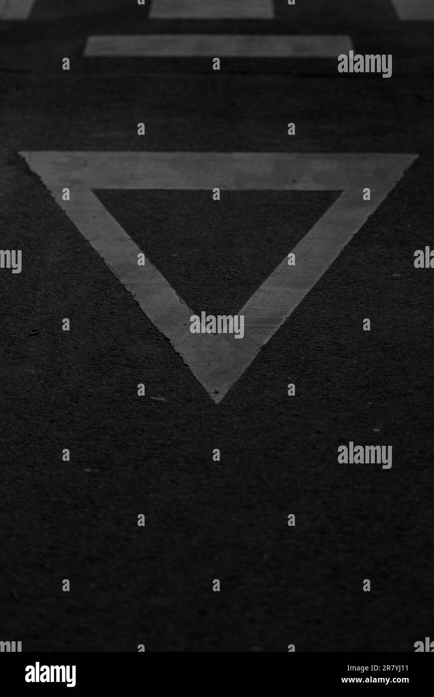 Un plan vertical d'un panneau de signalisation en forme de triangle sur l'asphalte Banque D'Images