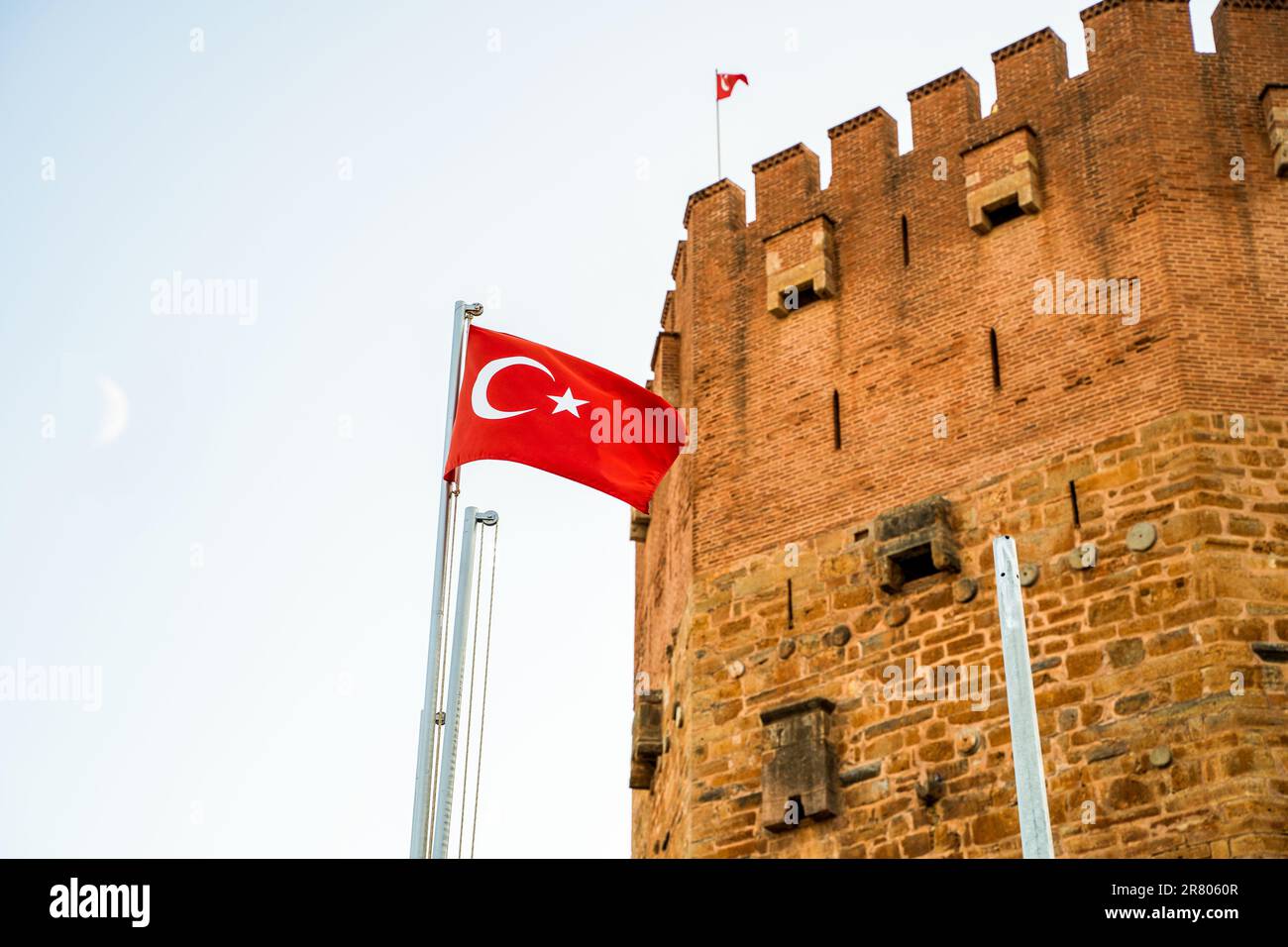Drapeau de la Turquie en demi-lune pendant la journée contre le mur du fort du château de Twierdza Ehmedek alanya Banque D'Images