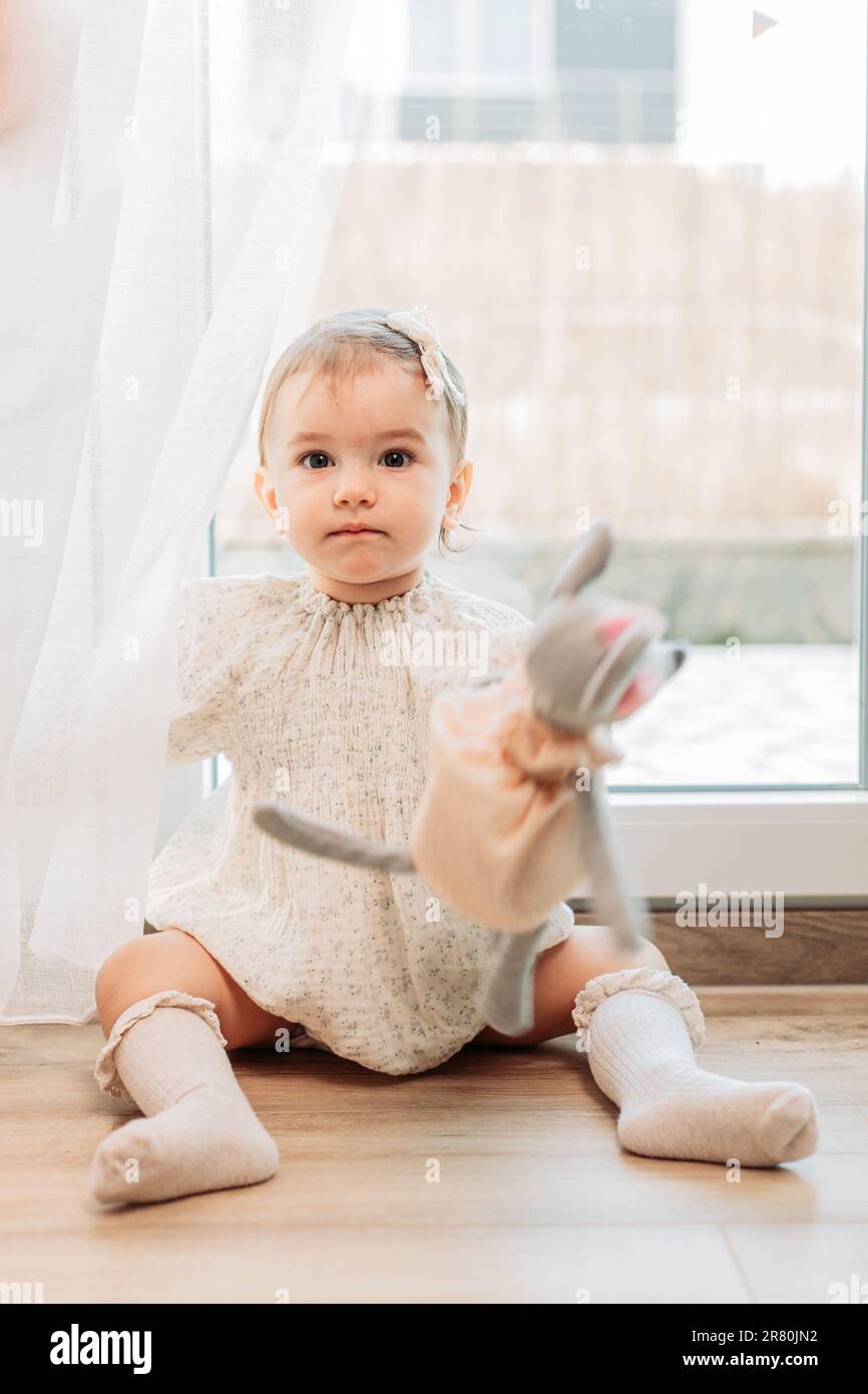 Portrait d'une petite fille d'un an assise sur le sol Banque D'Images