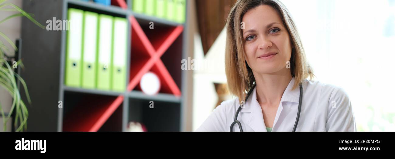 Portrait d'une femme souriante médecin avec stéthoscope en clinique Banque D'Images