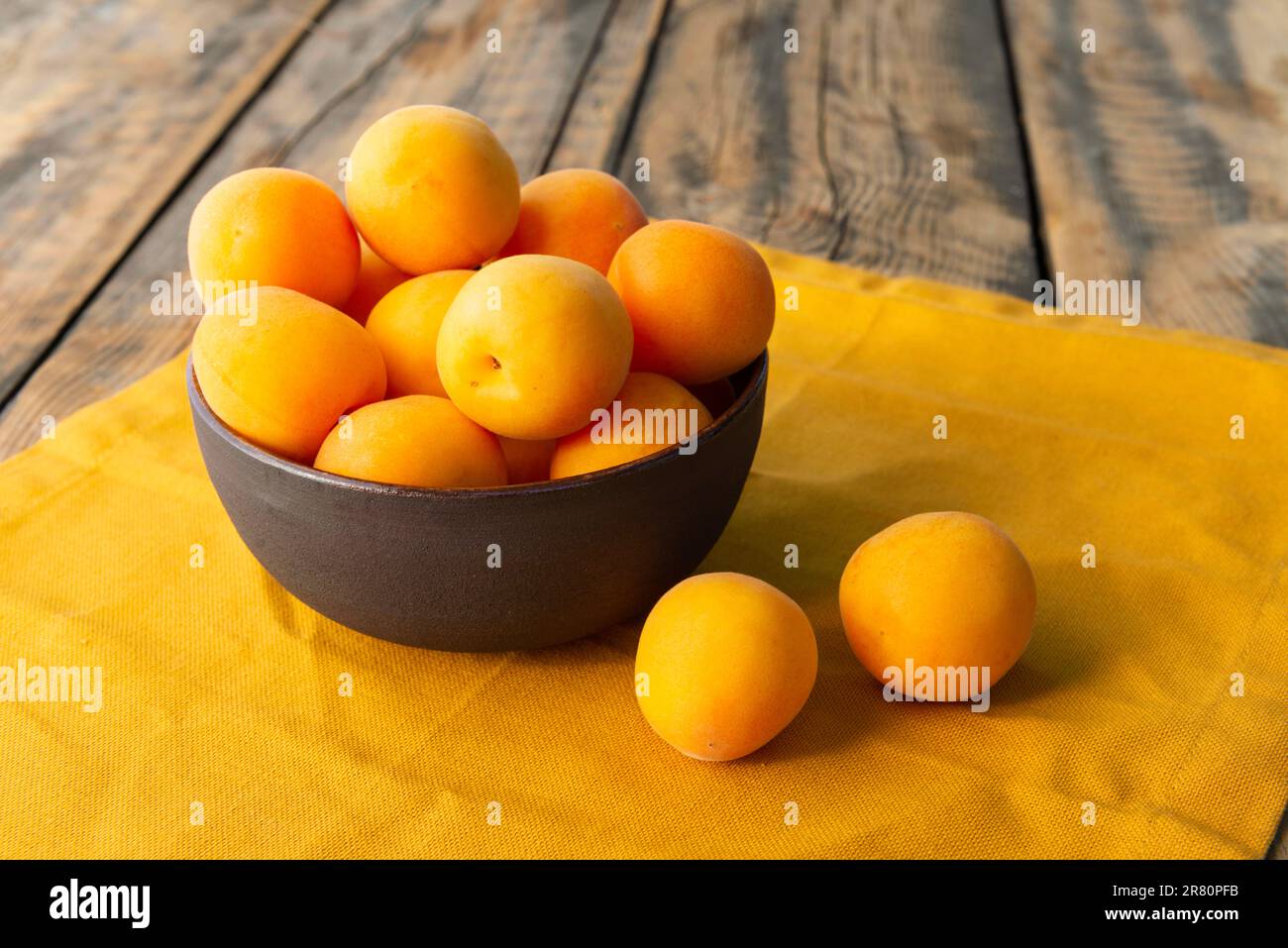 Abricots jaunes mûrs dans un bol sur une serviette de table Banque D'Images
