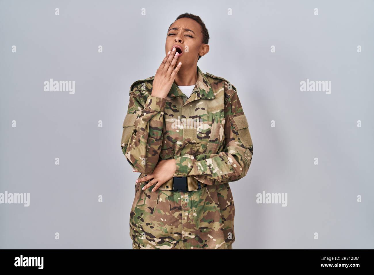Belle afro americaine femme portant l uniforme militaire de camouflage ennuye bailling fatigue couvrant la bouche avec la main. agite et somnolence Photo Stock Alamy