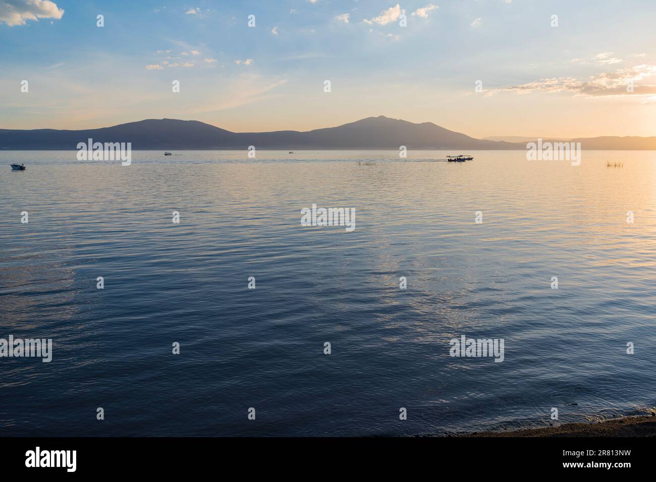 bateaux sur le lac chapala comme coucher de soleil et montagnes le long de l'horizon vue de malecon à chapala jalisco mexique Banque D'Images