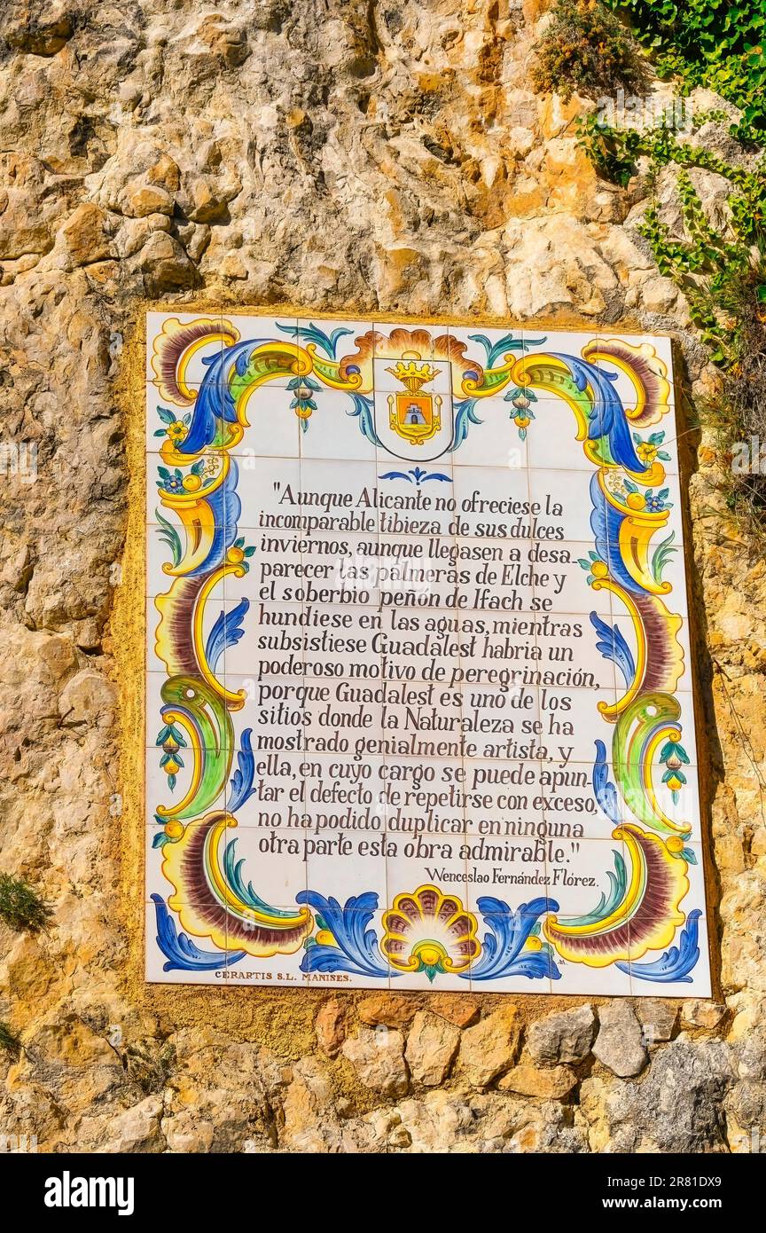 Guadalest, Alicante, Espagne - 14 janvier 2023: Une plaque de céramique placée sur un monticule de pierre orné d'une bordure de fleur. La formation rocheuse a un toucher Banque D'Images