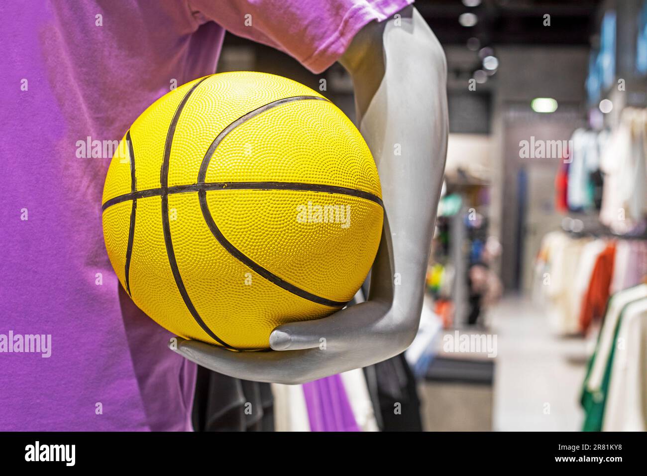 mannequin tenant un basket-ball jaune dans un magasin d'articles de sport Banque D'Images
