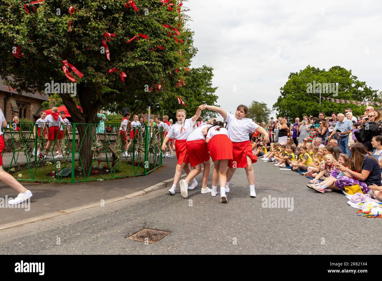 17 juin 2023 – Appleton Thorn, nr Warrington, Cheshire, Angleterre. Bawming (décorer l'arbre avec des fleurs et des rubans) l'épine est une cérémonie annuelle qui a lieu dans le village d'Appleton Thorn à Cheshire, en Angleterre. Appleton Thorn village est le seul village d'Angleterre où la cérémonie de mise en forme du Thorn a lieu le troisième samedi de juin de chaque année. Les enfants de l'année 6 de l'école primaire d'Appleton Thorn dansaient autour de l'arbre déchiré tout en chantant le chant de Bawming. Banque D'Images