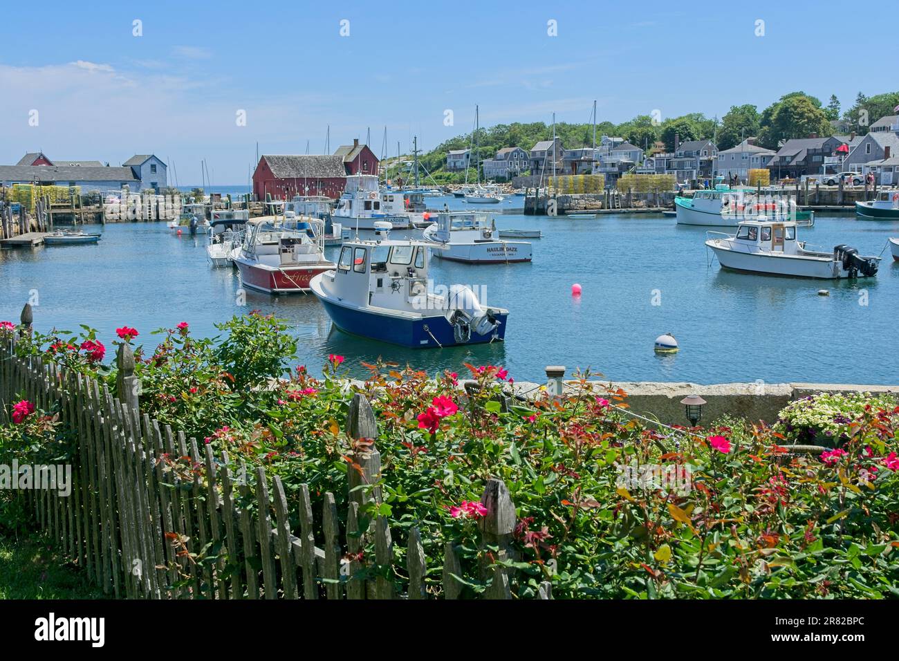 Rosiers et clôture en bois de piquet de pêche commerciale bateaux amarrés dans le port de Rockport et le site touristique motif Numéro un cabane de pêche Banque D'Images