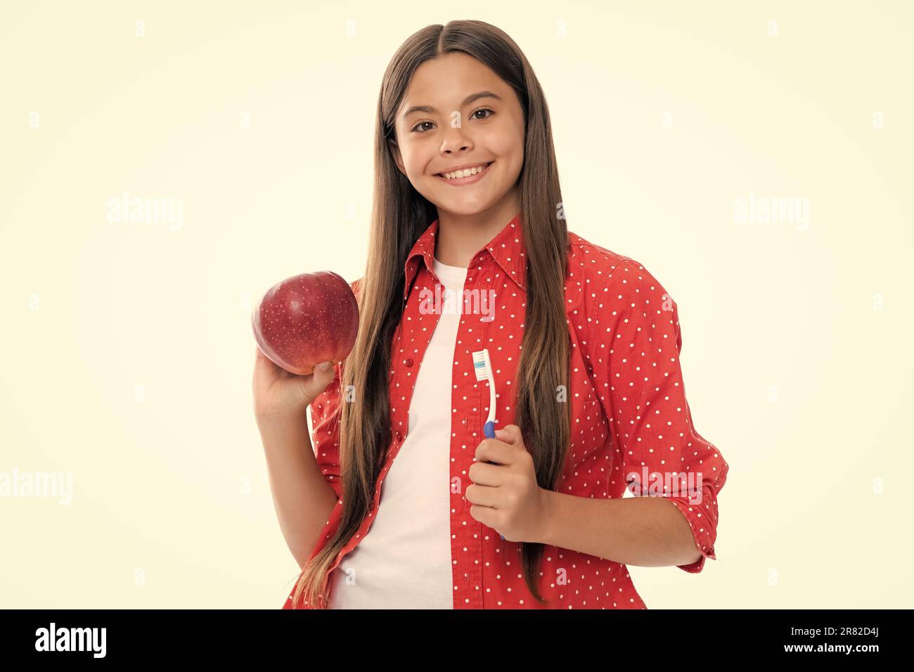 Une adolescente se brossant les dents sur un fond jaune isolé. Brosse à dents d'hygiène quotidienne pour adolescents, routine du matin. Soins dentaires soins buccaux. Banque D'Images