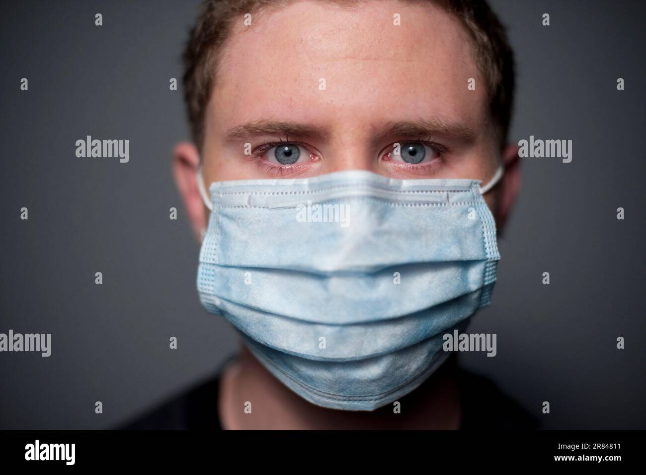 Studio gros plan portrait d'un homme caucasien de 17 ans portant un masque médical. Banque D'Images