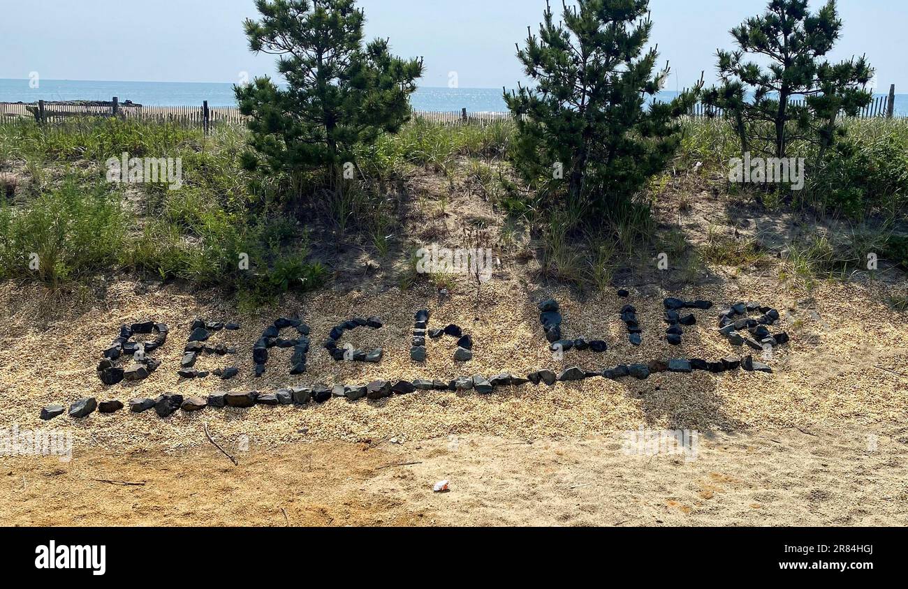 La vie sur la plage a été définie avec de petites roches noires sur une dune de sable à Asbury Park, New Jersey. Banque D'Images