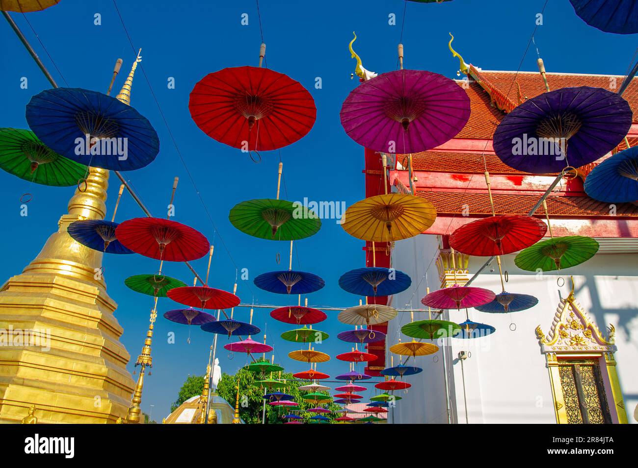 Parasols aux couleurs vives suspendus pour la décoration à l'entrée d'un temple en Thaïlande Banque D'Images