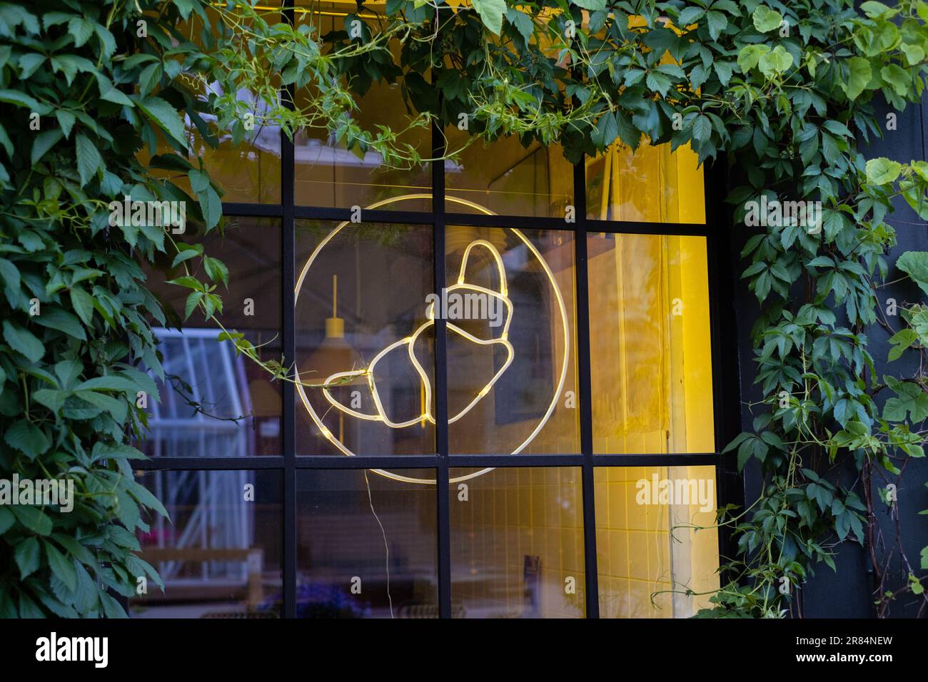 Panneau de signalisation lumineuse au néon croissant accroché à la fenêtre du café. Banque D'Images